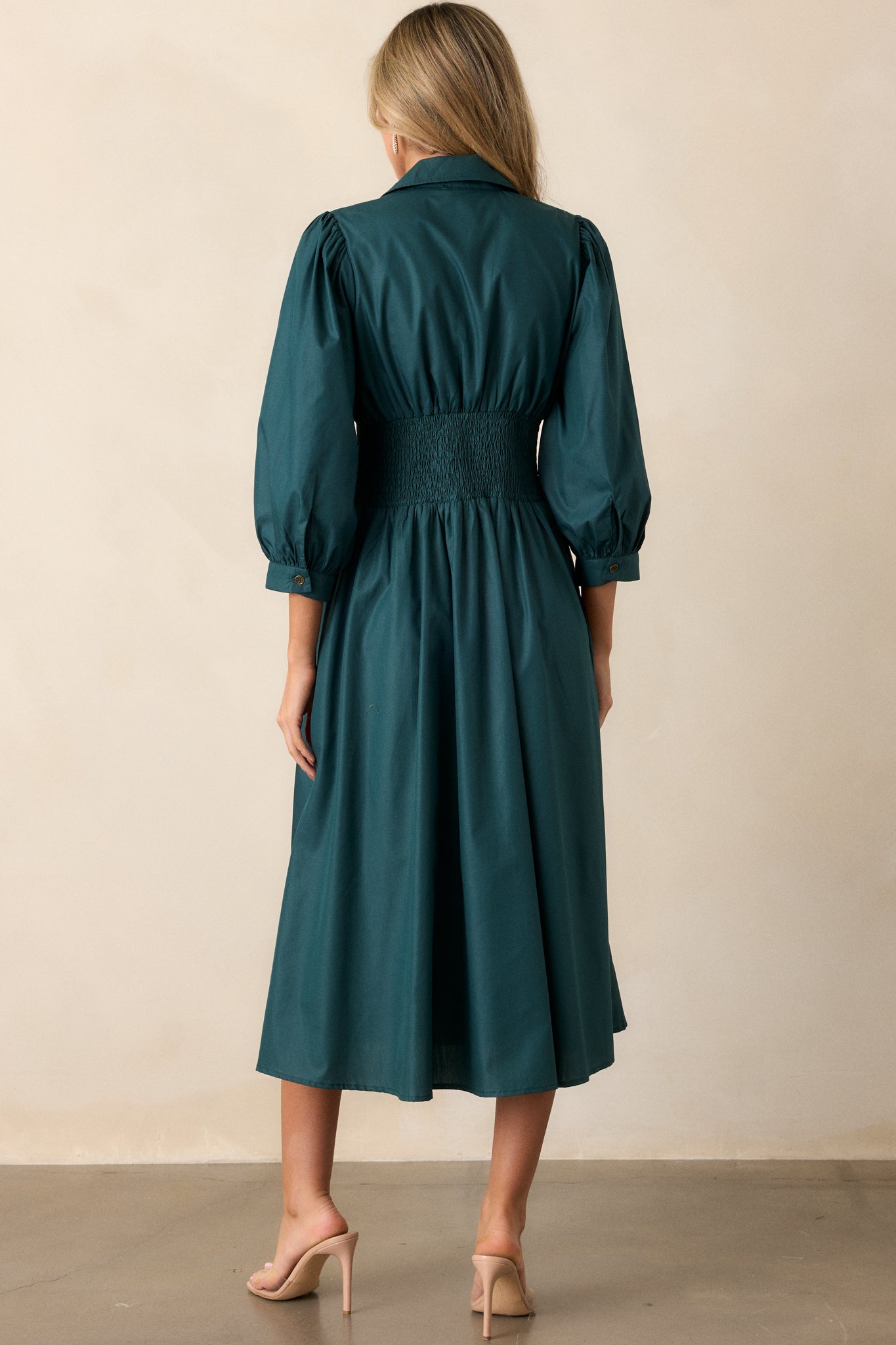 Back view of the forest green midi dress, displaying the smooth drape of the fabric from the shoulders down to the midi-length skirt.