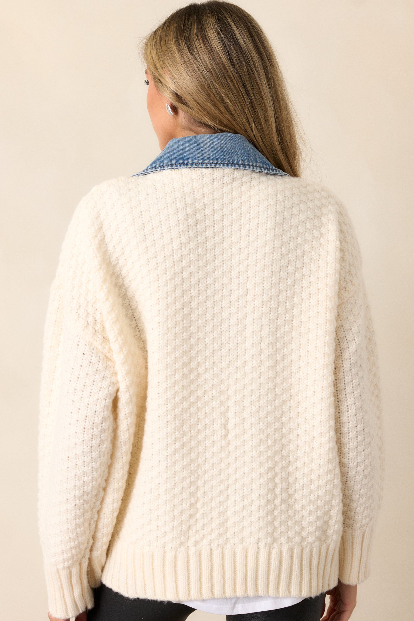 A back view of the jacket, showcasing the ivory knit mock sweater overlay, ribbed trim, and the subtle contrast between the knit fabric and denim accents.