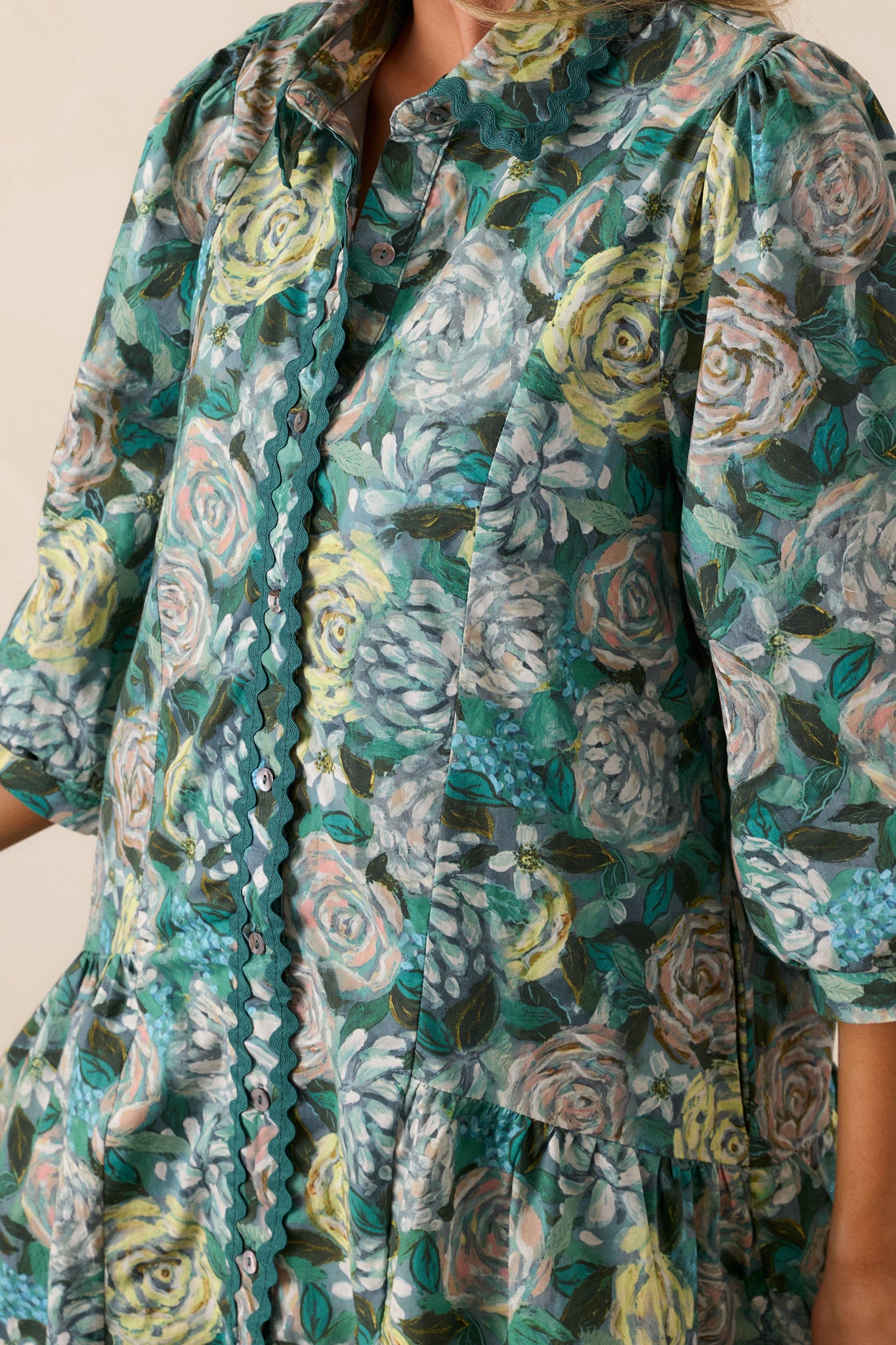 A detailed view of the painted floral pattern on the green fabric, highlighting the delicate details and texture of the design.