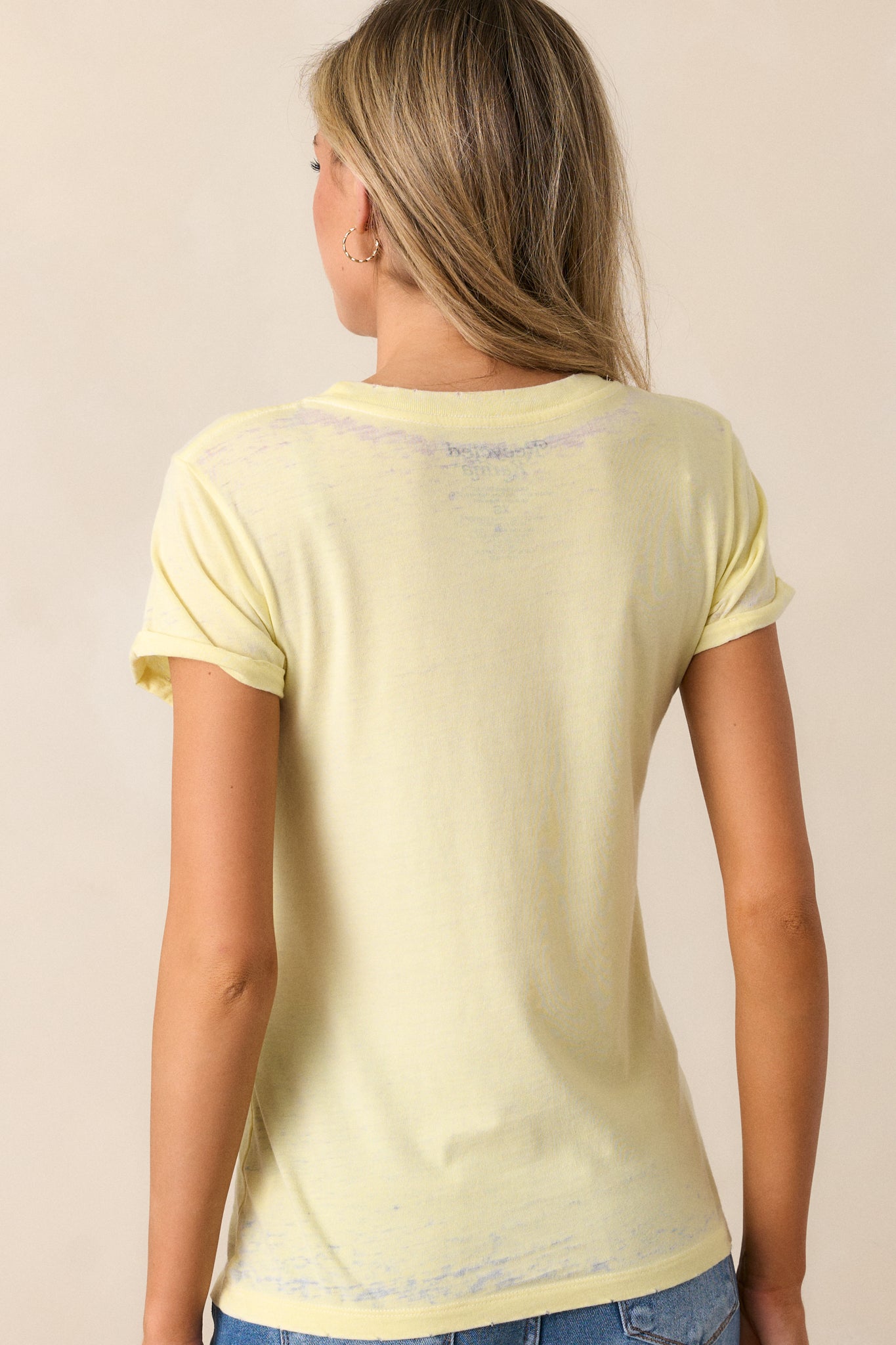 Back view of the light yellow tee, showing its simple design with no graphic and the clean, unembellished style.