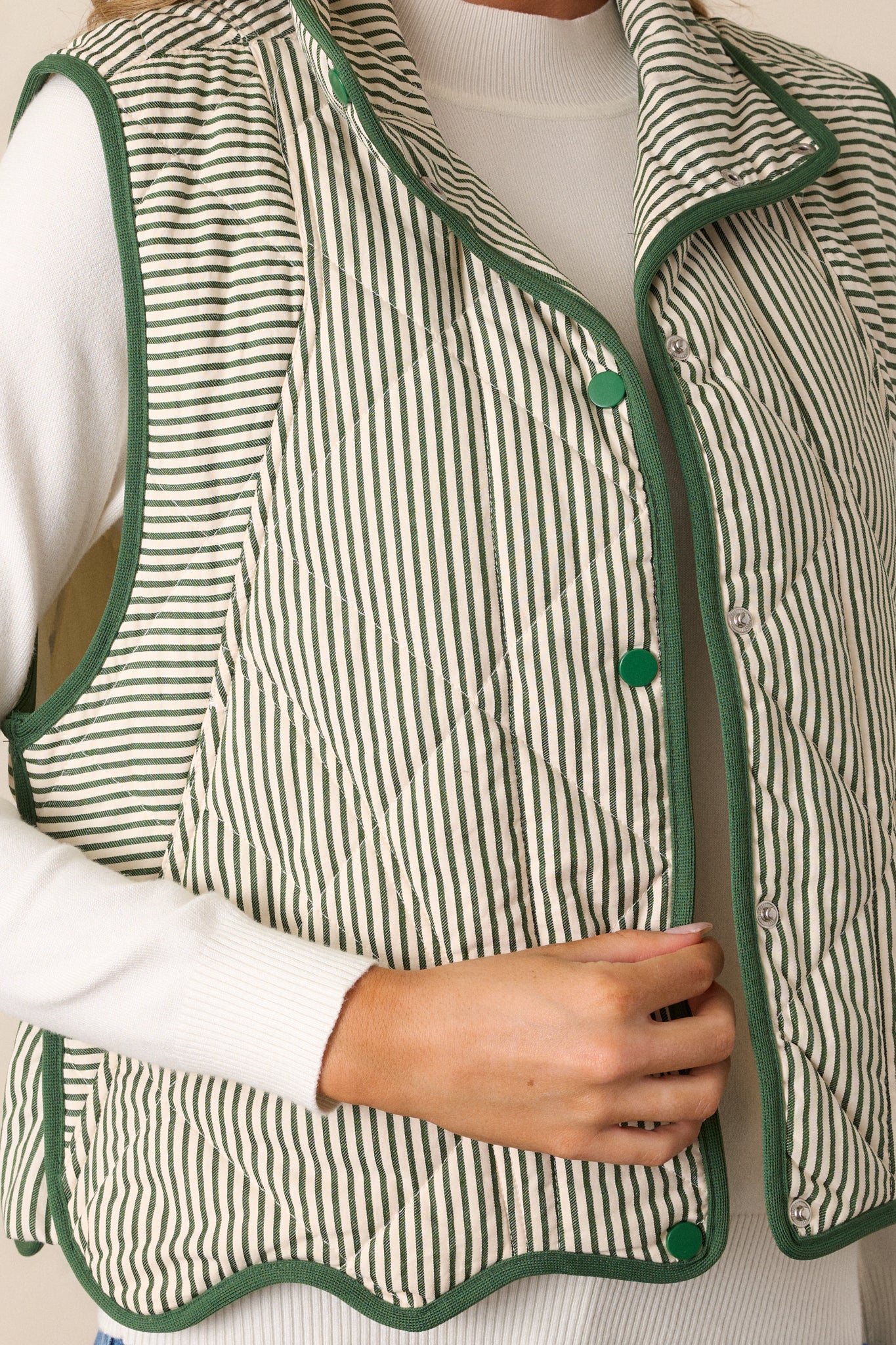 Close-up of the quilted pattern and stripe detailing on the vest, capturing the texture and deep green color.