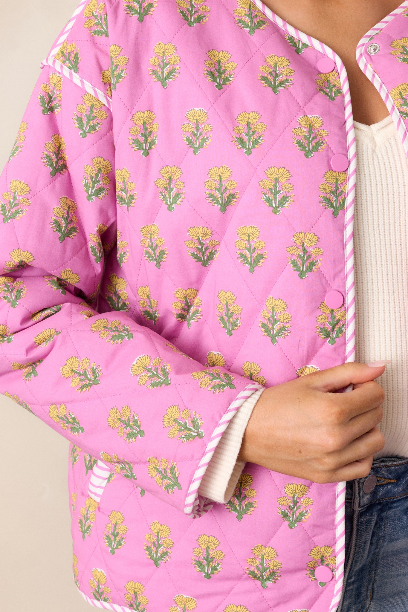 A detailed view of the pink jacket’s floral print, focusing on the delicate texture and vibrant pattern.