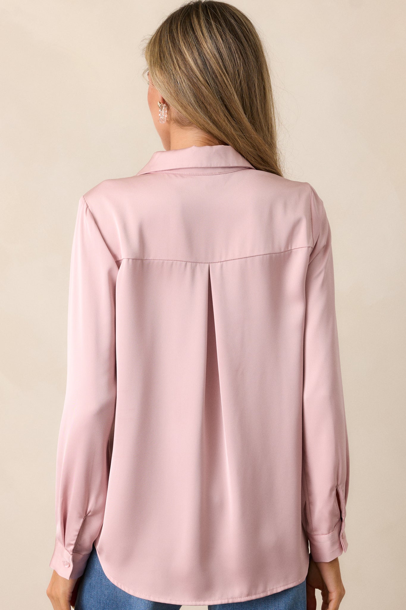 A back view of the dusty pink top showcasing the relaxed fit and smooth fabric extending down the back.