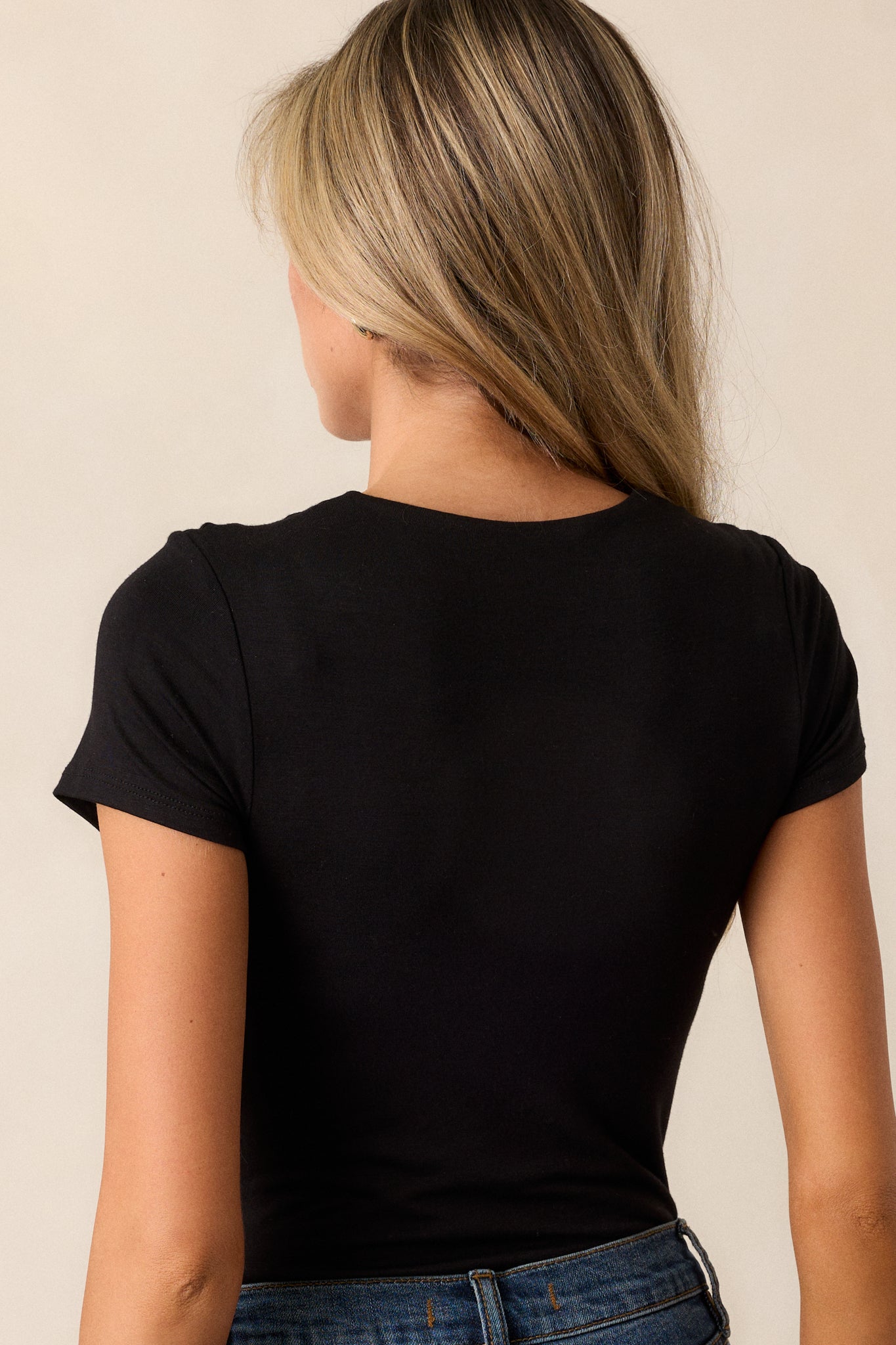 Back view of the black bodysuit highlighting the seamless design and the fitted shape