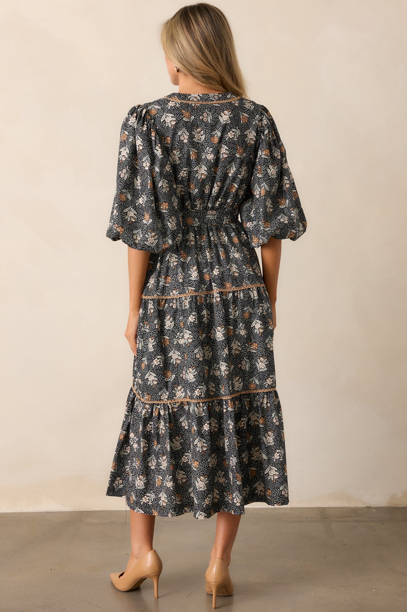 Back view of the dress, showing the smooth fall of the fabric, the continuity of the floral pattern, and the subtle gathering of the tiered skirt.