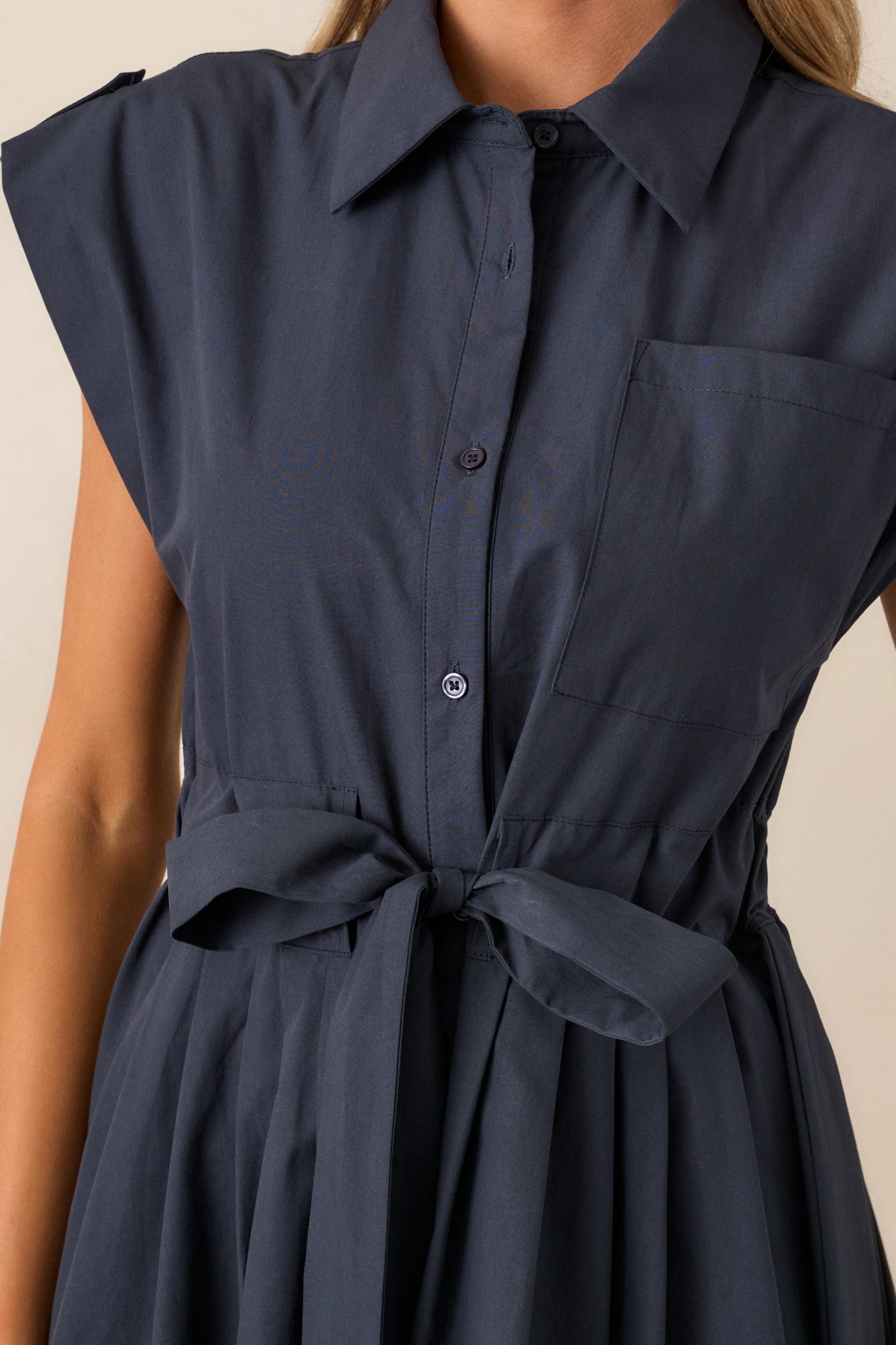 A close-up view highlighting the texture of the navy fabric, showcasing the functional button front and the intricate detailing of the self-tie belt.