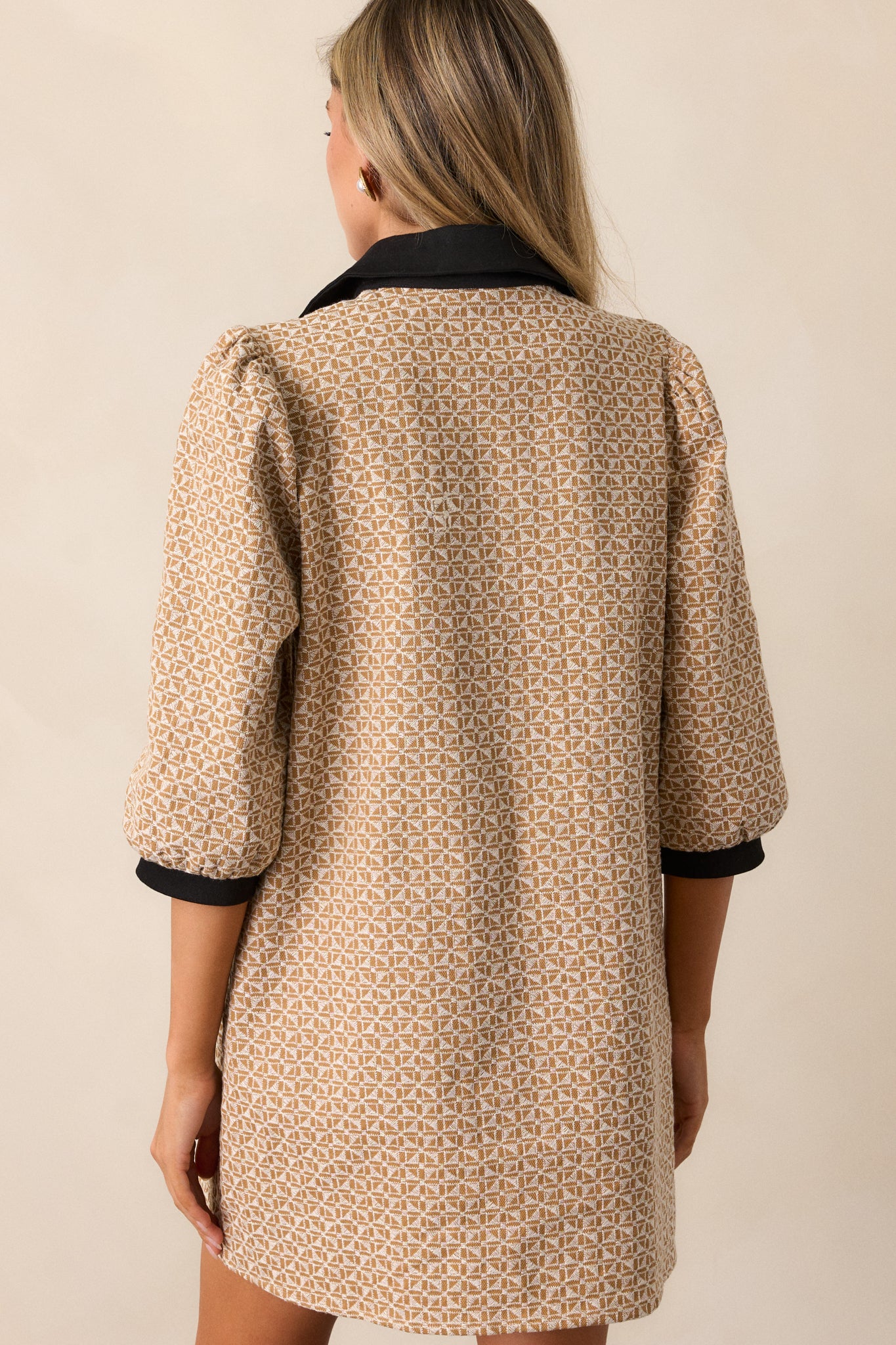 Back view of the honey mini dress, revealing its shift cut, geometric jacquard design, and black collar from behind.