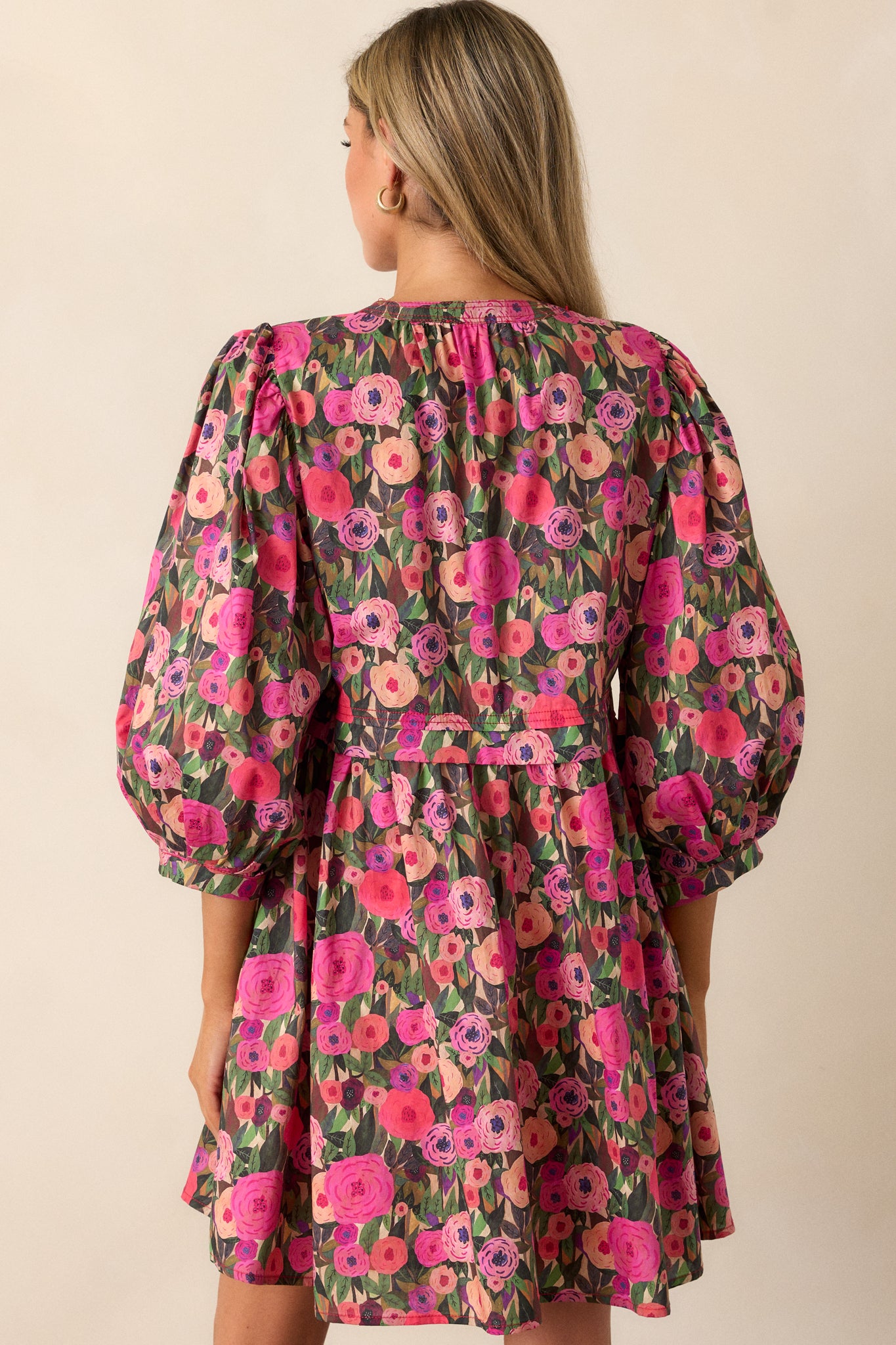 Back view of the pink mini dress featuring an a-line cut and subtle floral design.