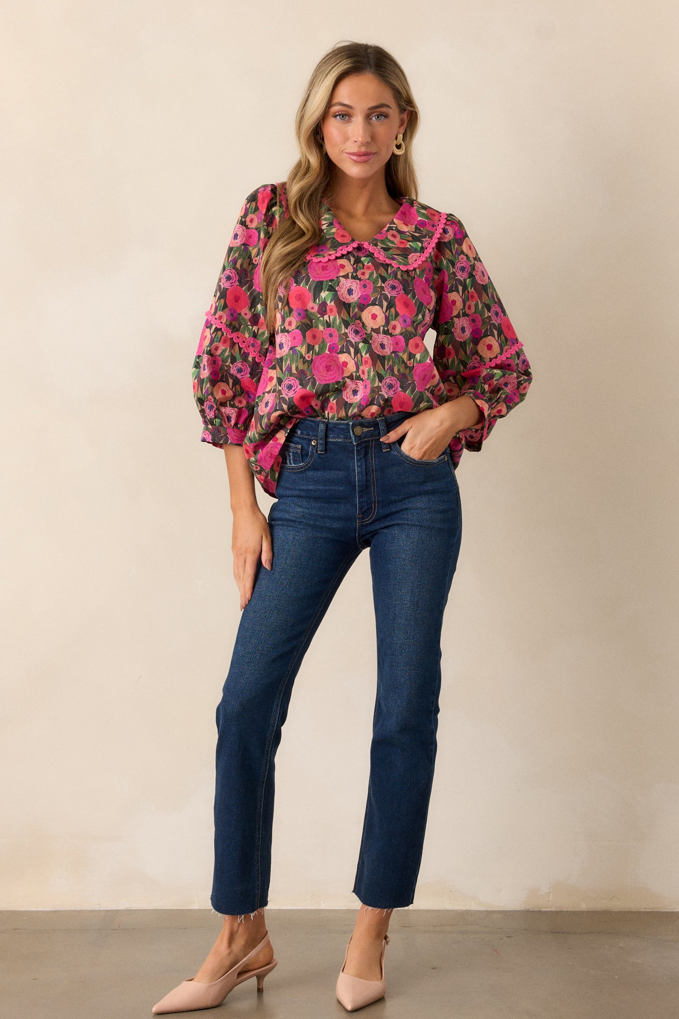 A full-length view of a pink blouse featuring a peter pan collar with scalloped trim, floral design, and 3/4 length puff sleeves.