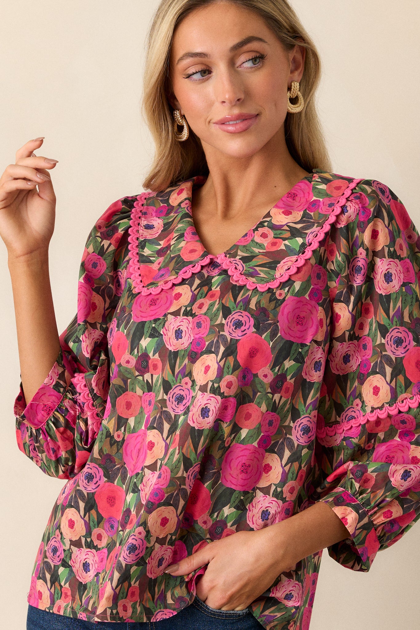 Close-up view showing the 3/4 length puff sleeves with scalloped trim detailing on the pink blouse.