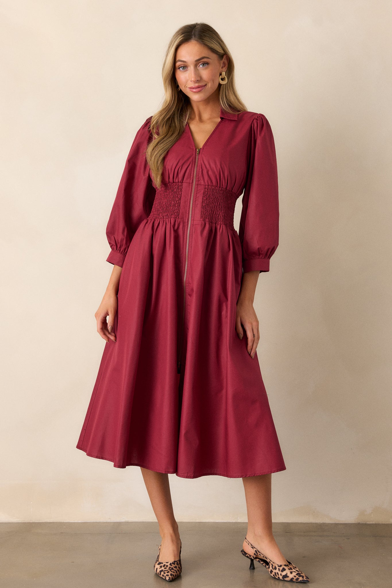 Full-length view of the dress from an angle, focusing on the structured collar, v-neckline, and 3/4 sleeves with cuff detail.
