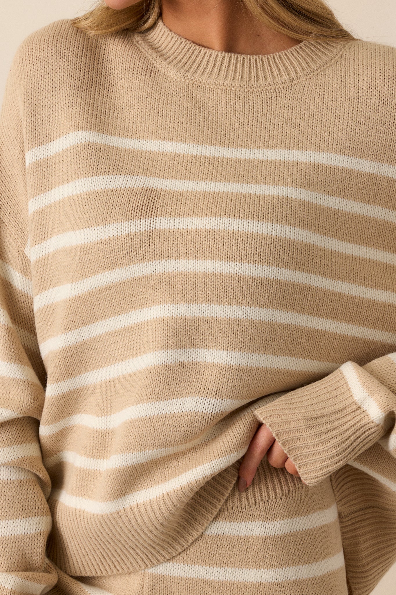 A front-facing view of the sweater, emphasizing the contrast between the taupe and ivory horizontal stripes and the ribbed neckline.