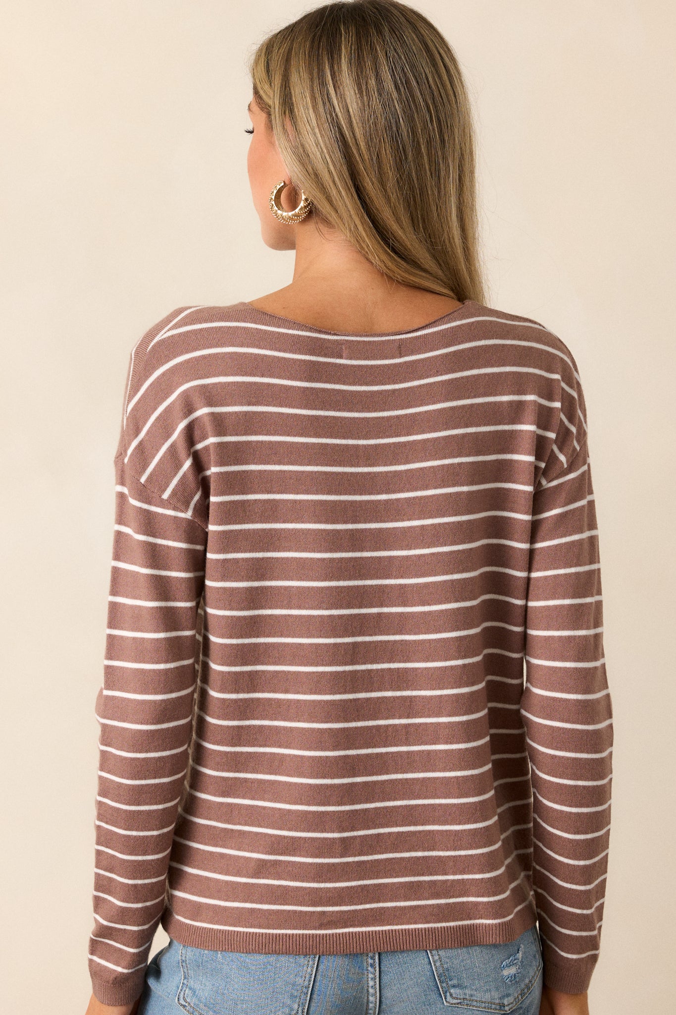 A back view of the light mocha top, featuring the long sleeves and relaxed silhouette. The back remains simple with no front seam detailing, and the thin white stripes continue across the fabric, giving it a clean, uniform look.