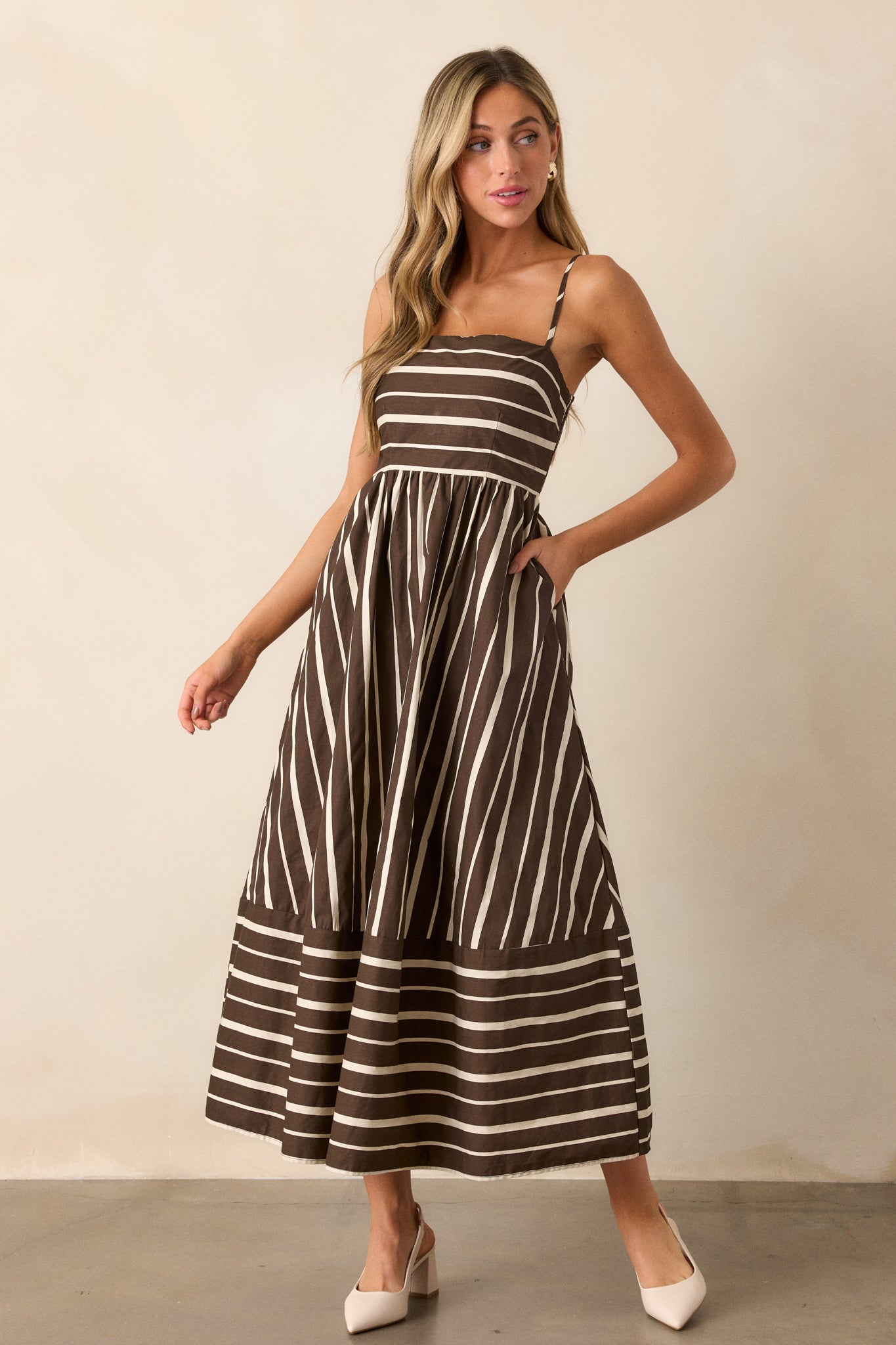 Full-length view of the brown dress, showcasing the square neckline and sleeveless design, with the mix-matched stripe pattern creating visual interest.