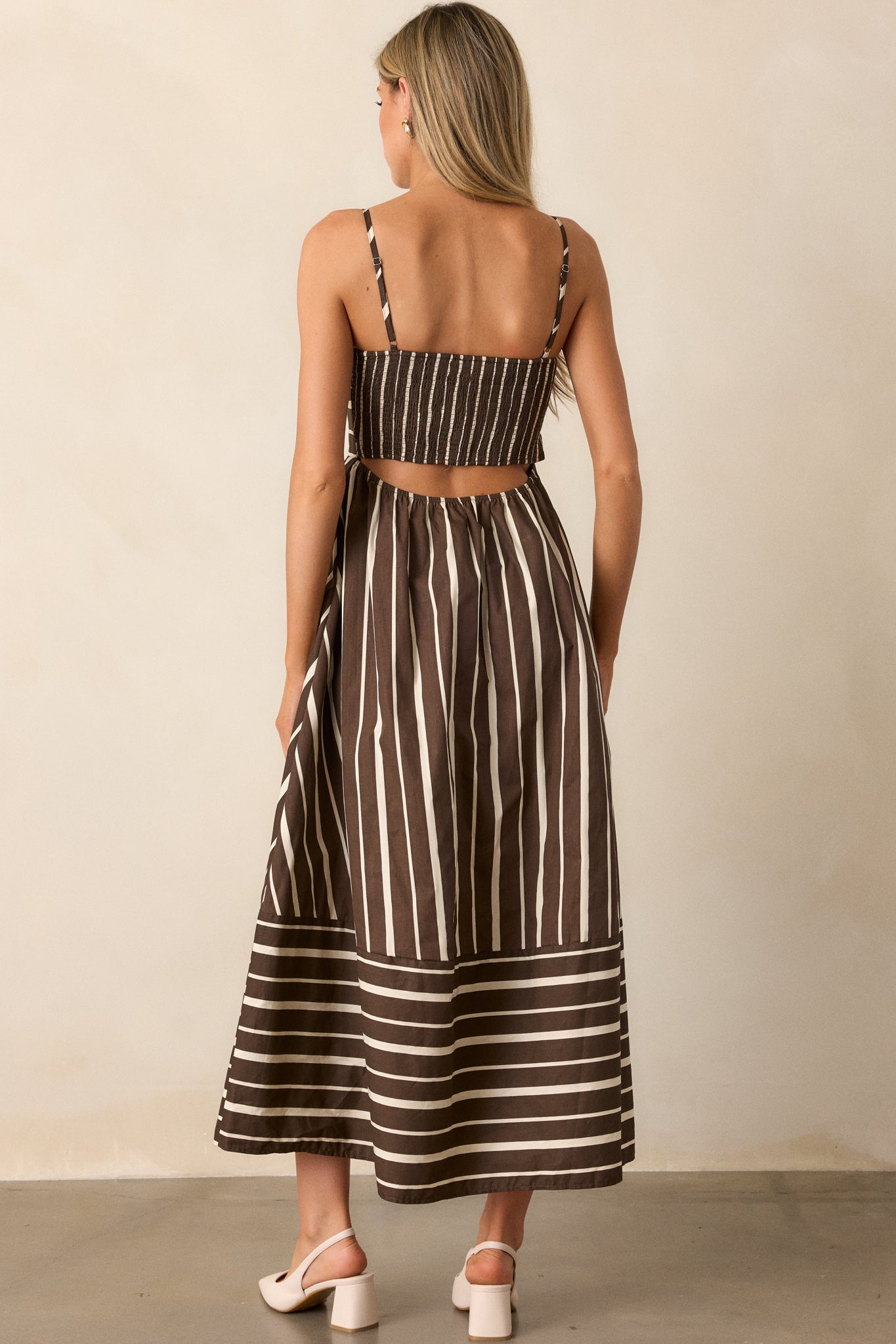 Rear view of the brown dress, focusing on the smocked back detailing and the open back design that adds an elegant touch to the midi-length silhouette.