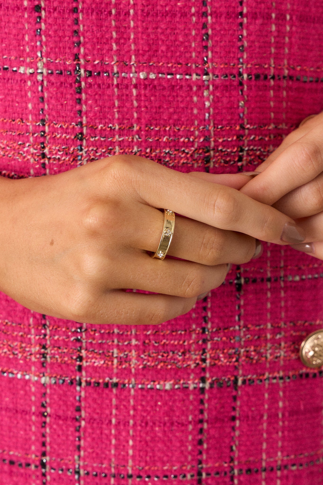 Extreme close-up of the gold ring, highlighting the sunken center and sparkling floral rhinestone accents against the shiny gold surface.