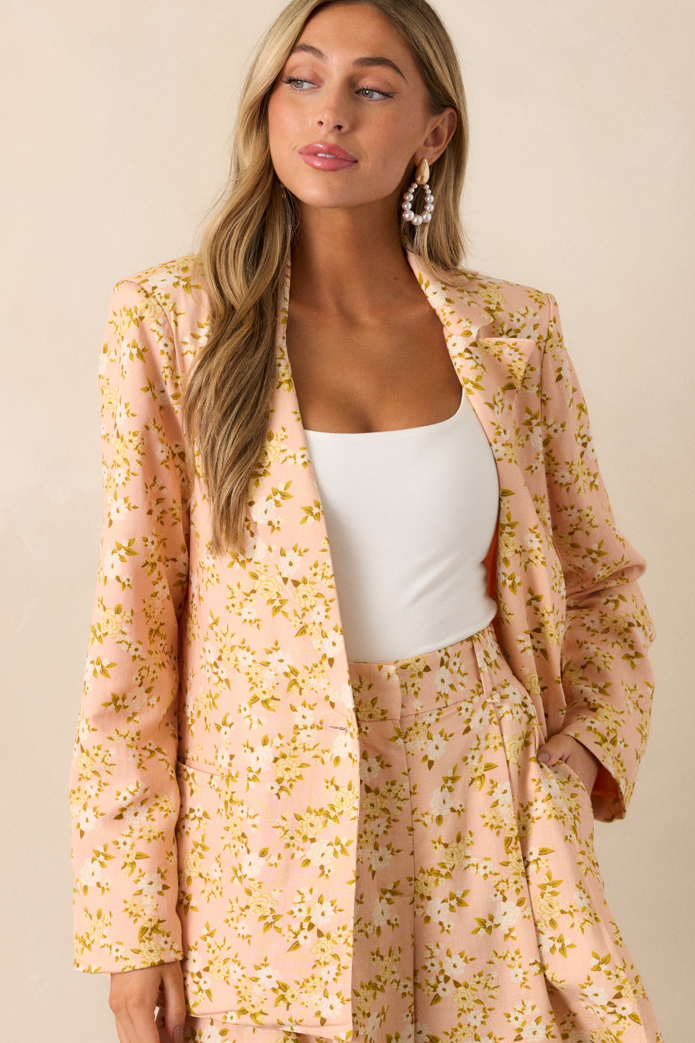 Close-up of the peach blazer’s lapel-collared neckline, showcasing the ditsy floral pattern and soft fabric drape.