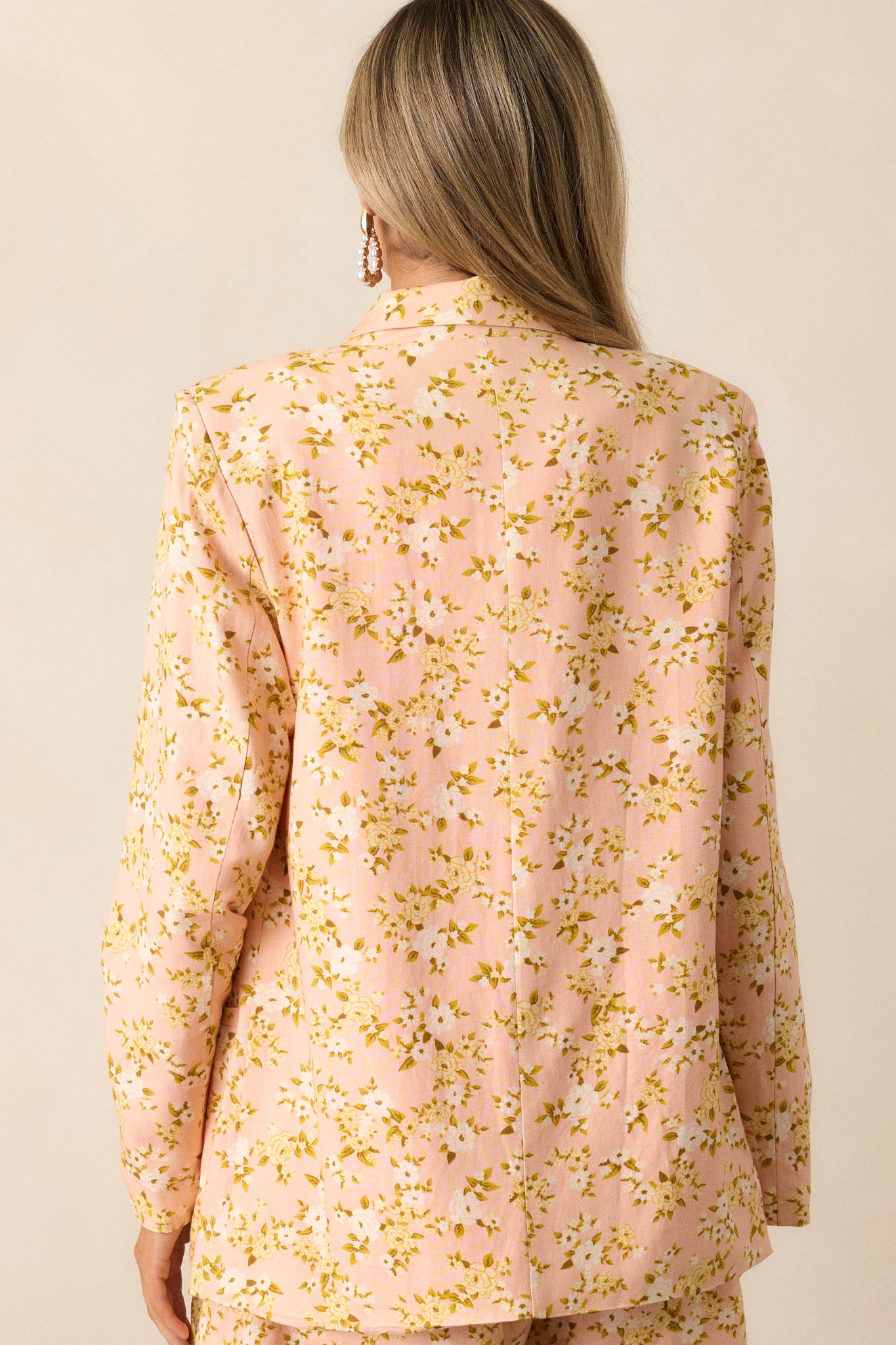 Back view of the peach blazer, showing the seamless continuation of the ditsy floral pattern and its tailored back seams.