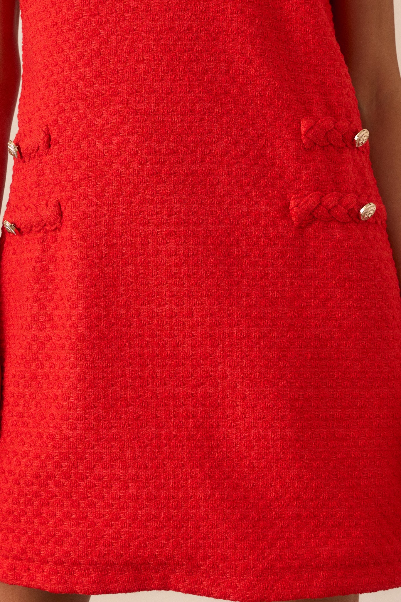 Close-up of the gold lion head buttons and braided trim along the front of the dress, showing intricate detailing.