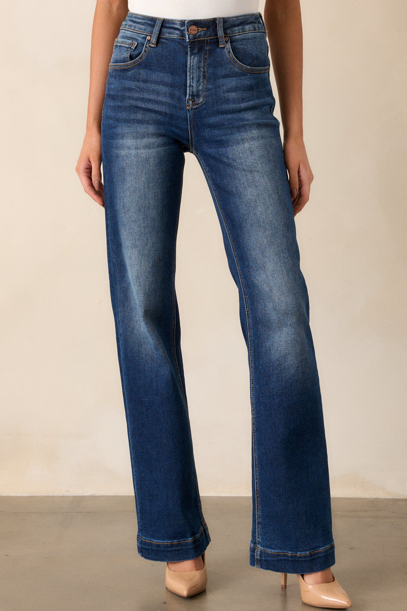 These dark wash jeans feature a high waisted design, functional belt loops, functional hip and back pockets, a dark wash design with faded thighs and knees and a straight leg.