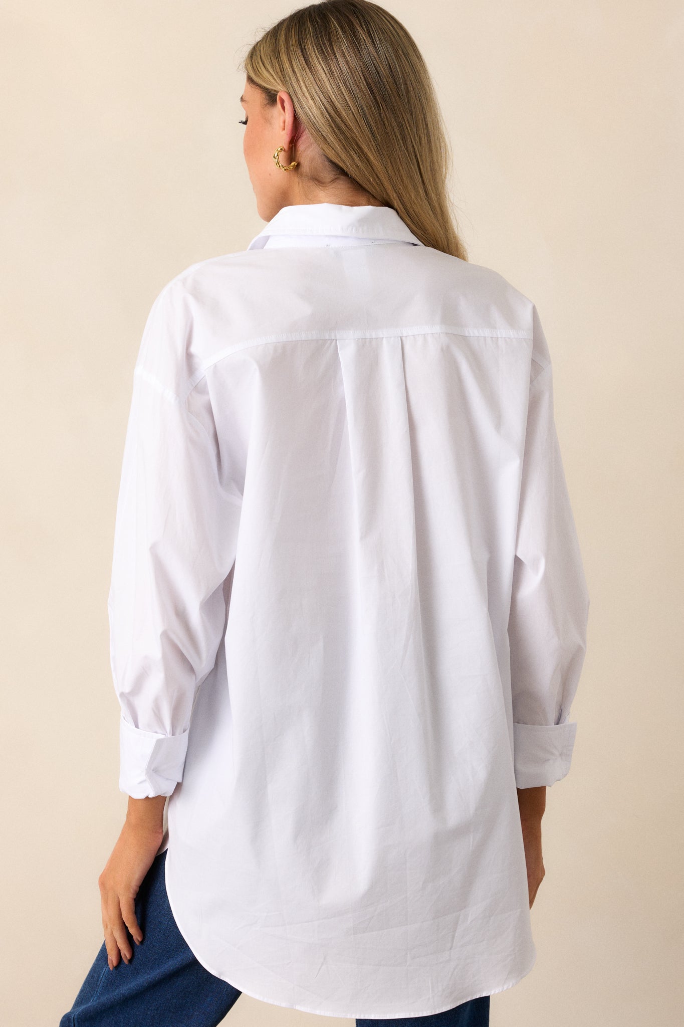 Rear view of the white top showing its clean, seamless design and the flow of the balloon sleeves from behind.