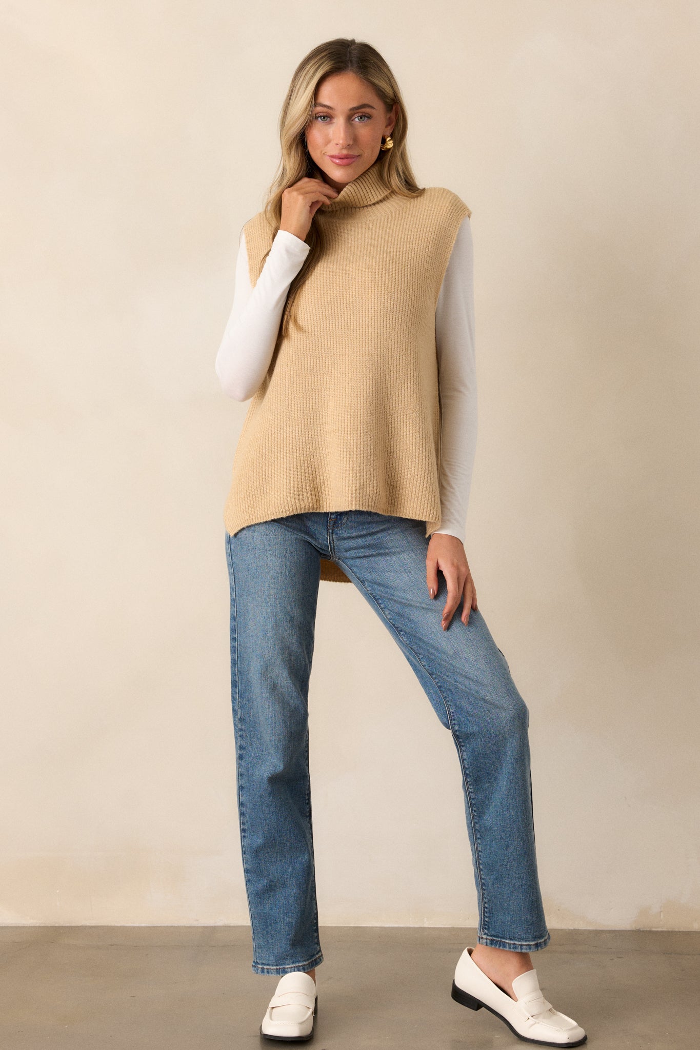 Front-facing view of the taupe sweater vest, focusing on the ribbed turtleneck and the soft sweater material, flowing down to the waist.