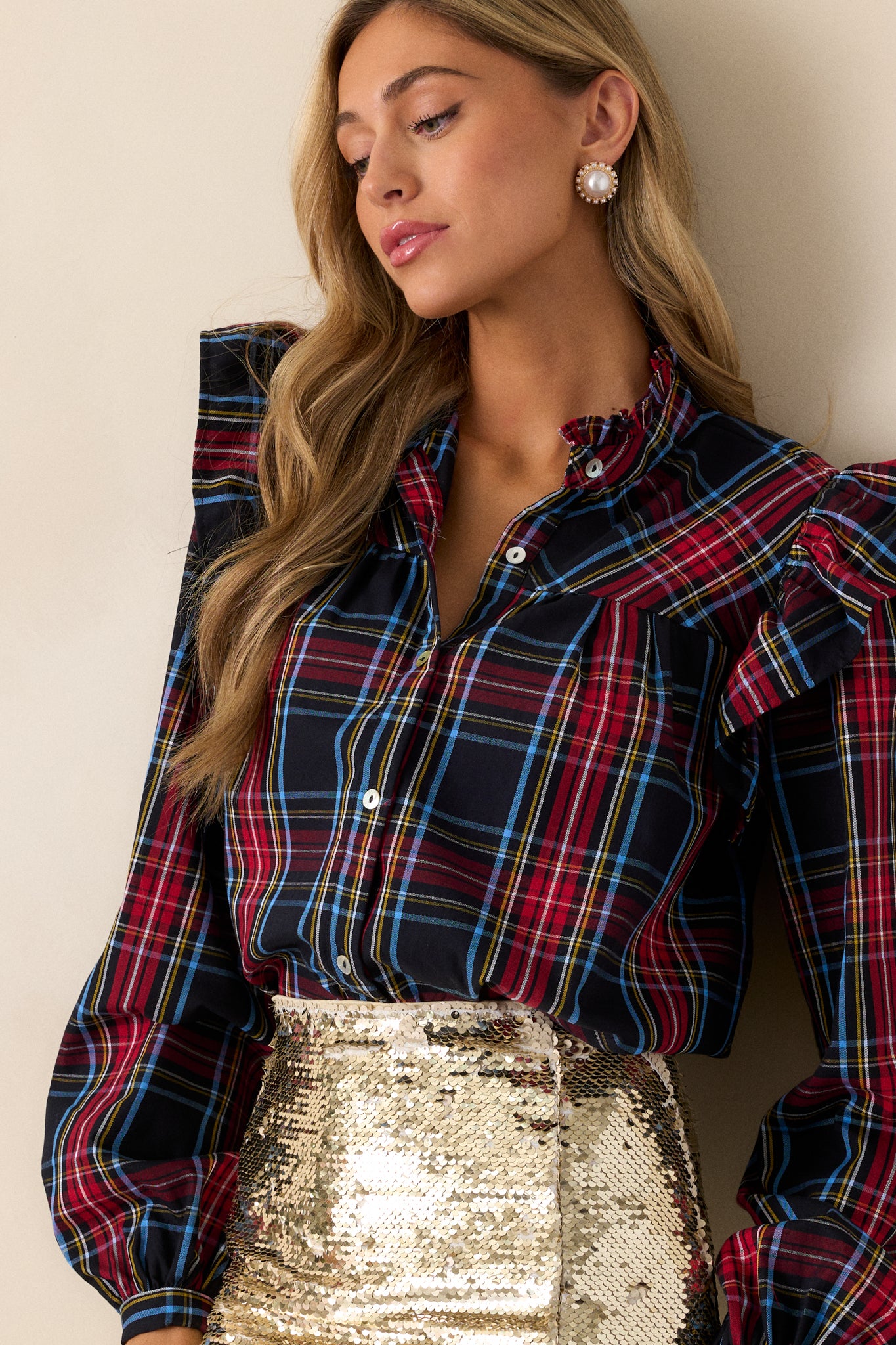 Front view of  this top that features a ruffle round neckline, ruffle sleeve detail, functional buttons down the center, wide sleeves, and buttoned cuffs. 