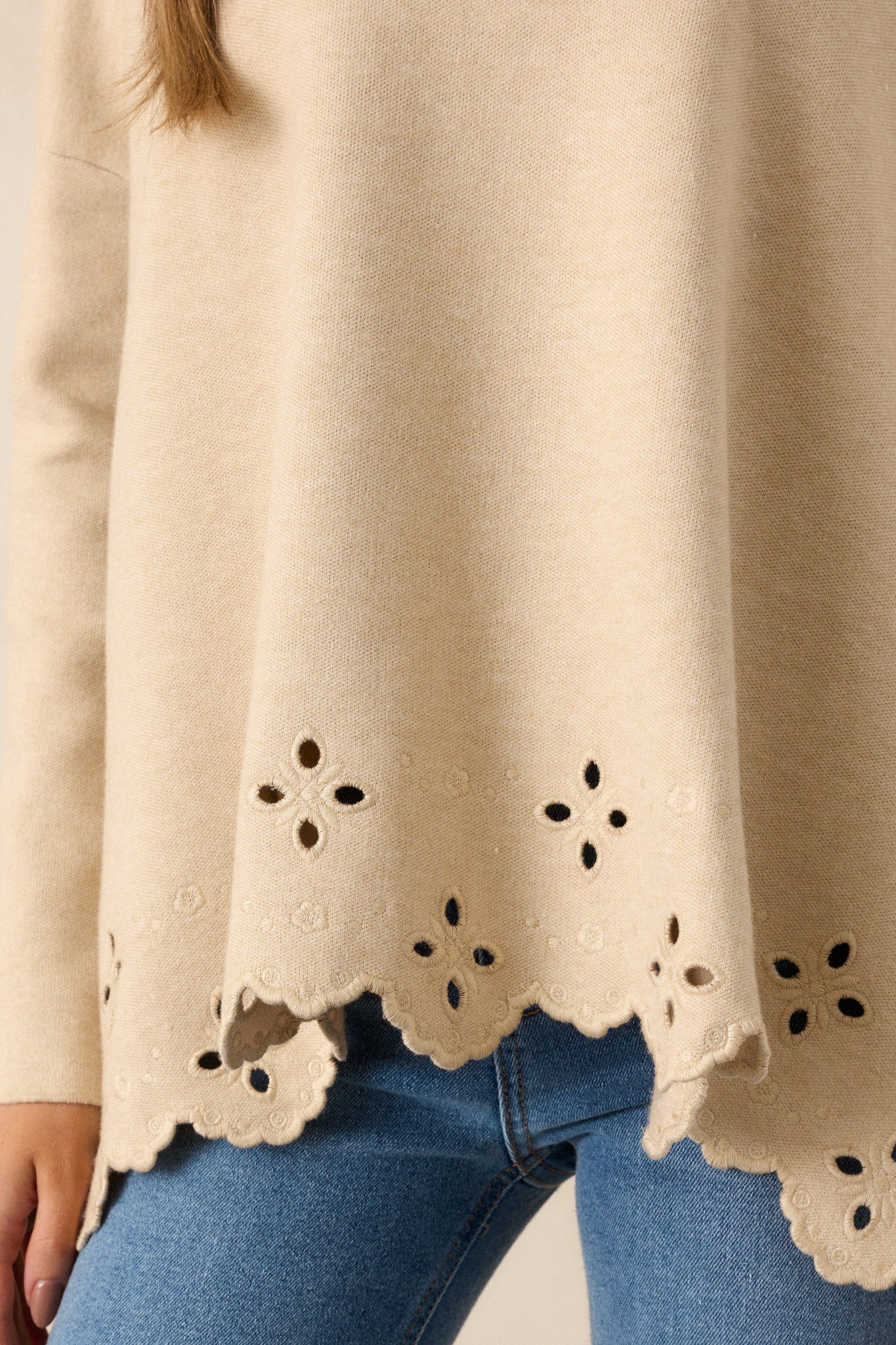 A close-up of the scalloped eyelet hem, highlighting the intricate detailing and the soft edge of the sweater's bottom.