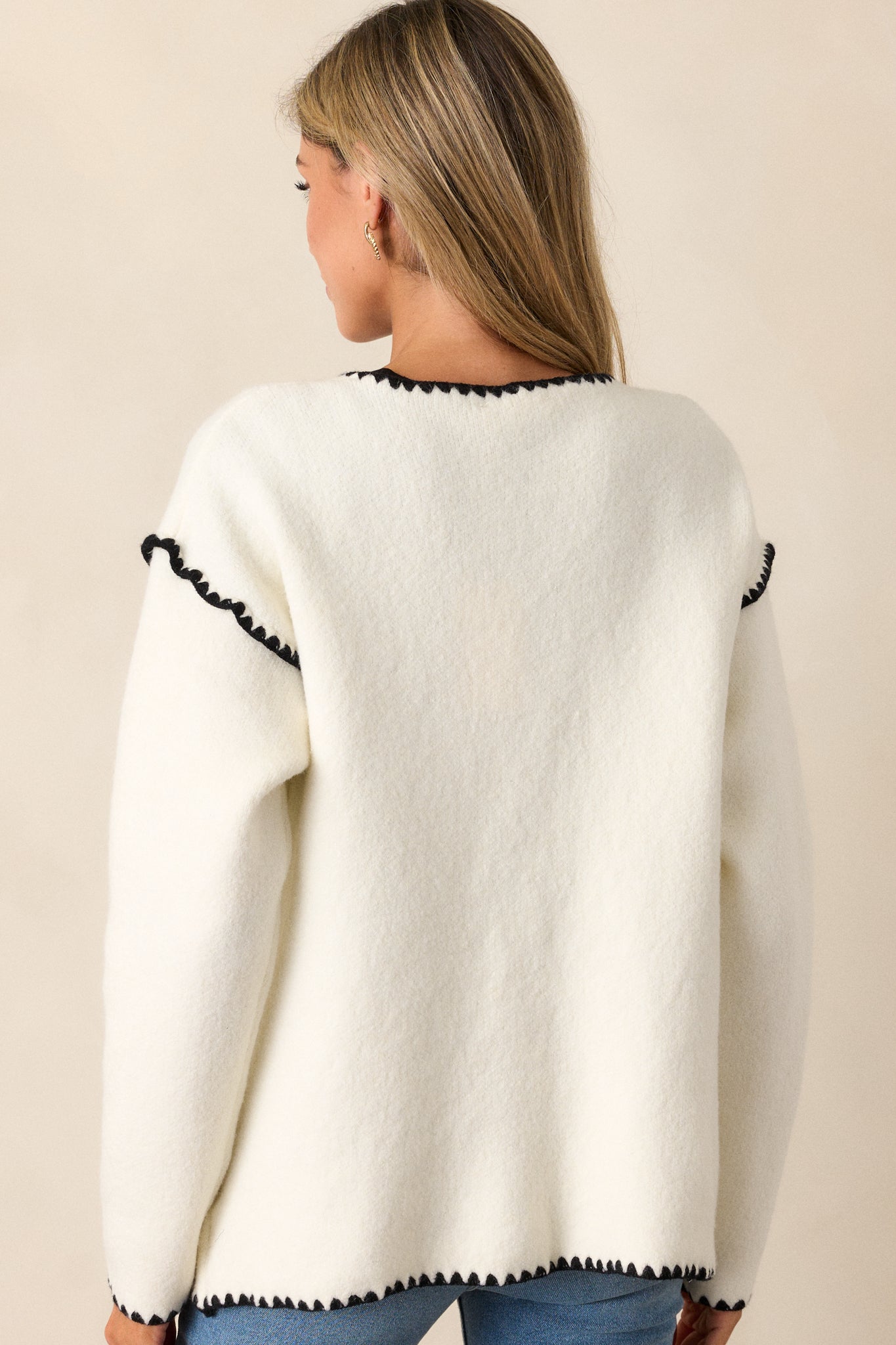 Back view of the cardigan, displaying the black blanket stitch trim along the hem and neckline from the back.