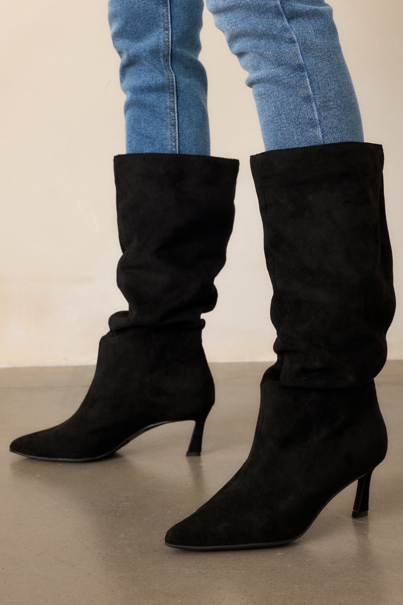  A side angle of the boots, showcasing the mid-calf design and the small heel that adds a touch of elegance to the overall silhouette.