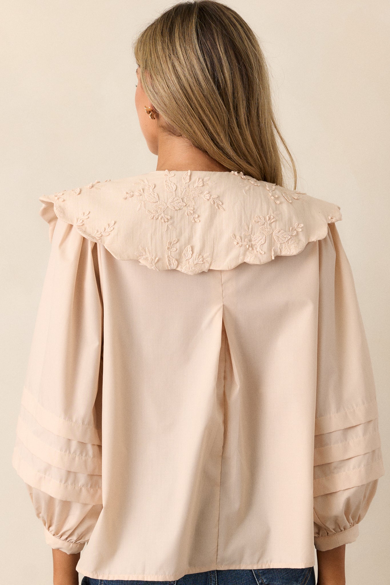 Rear view of the blouse, focusing on the smooth back panel and the continuation of the puff sleeve design.