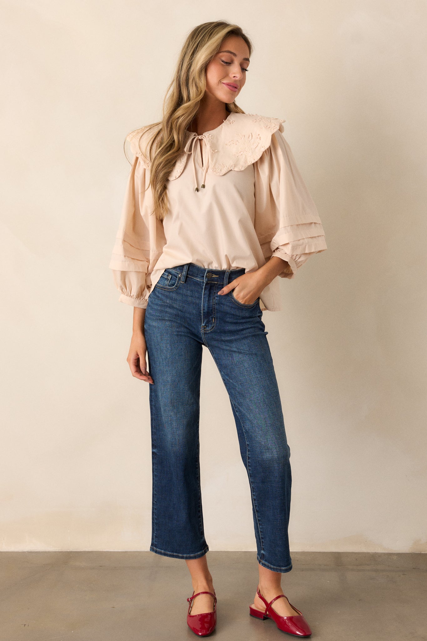 Full-length view of the ecru blouse, highlighting the large scalloped collar with floral embroidery and the long puff sleeves with pleated detailing.