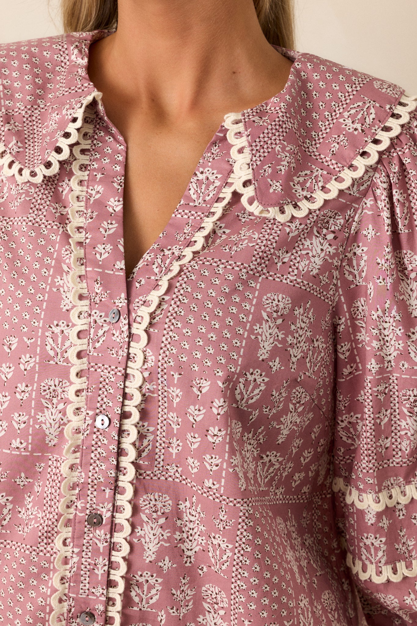 Detailed shot of the ivory floral pattern, functional buttons, and the ivory scallop detailing along the collar and buttons.