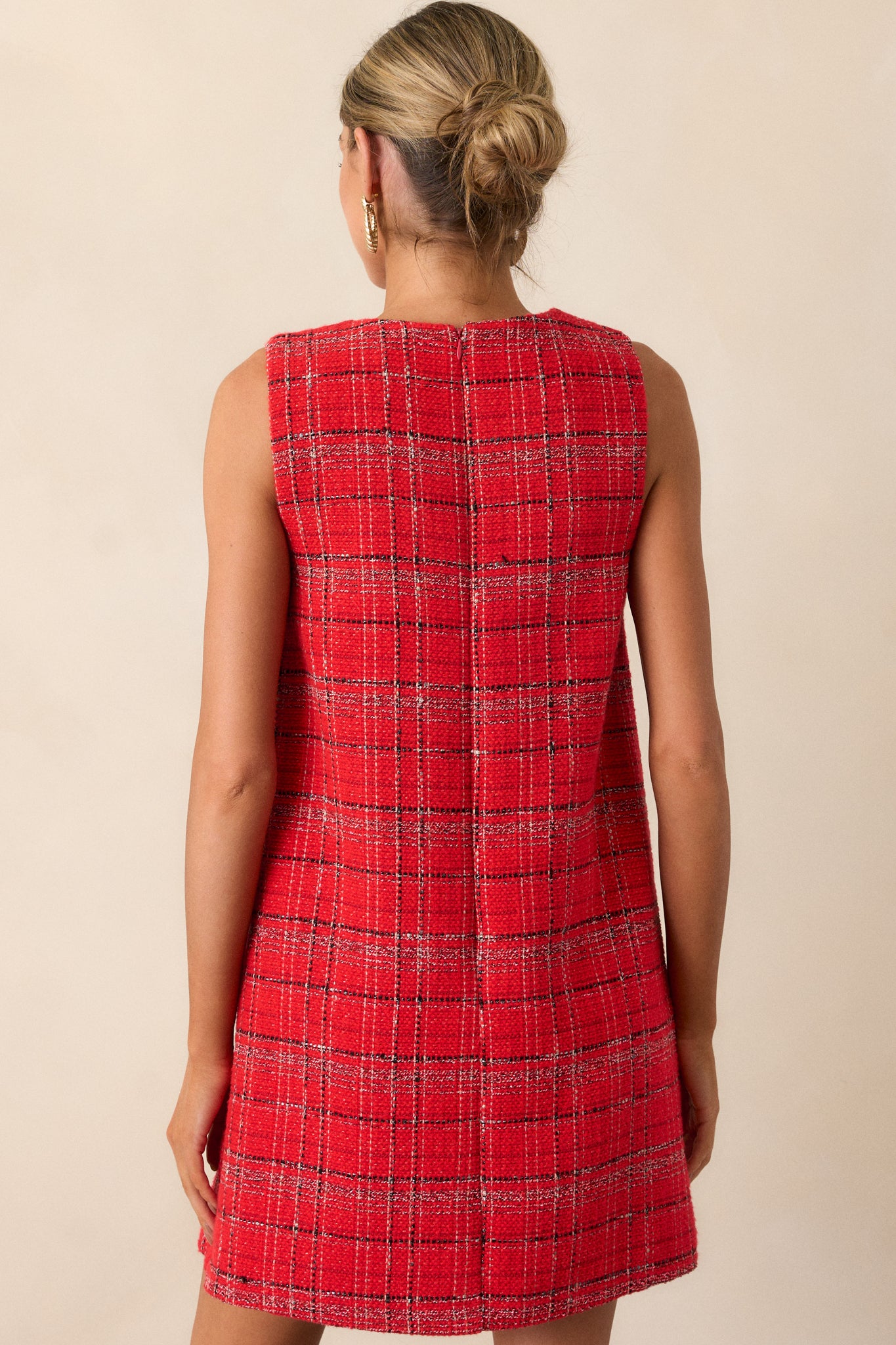 The back of the red mini dress featuring a clean, smooth silhouette with a discreet zipper running down the center.