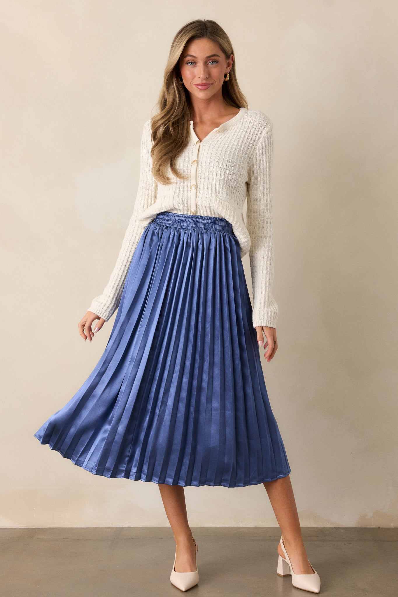 Full view of the dusty blue midi skirt, showcasing the pleated fabric that flows elegantly from the elastic waistband to the midi length.