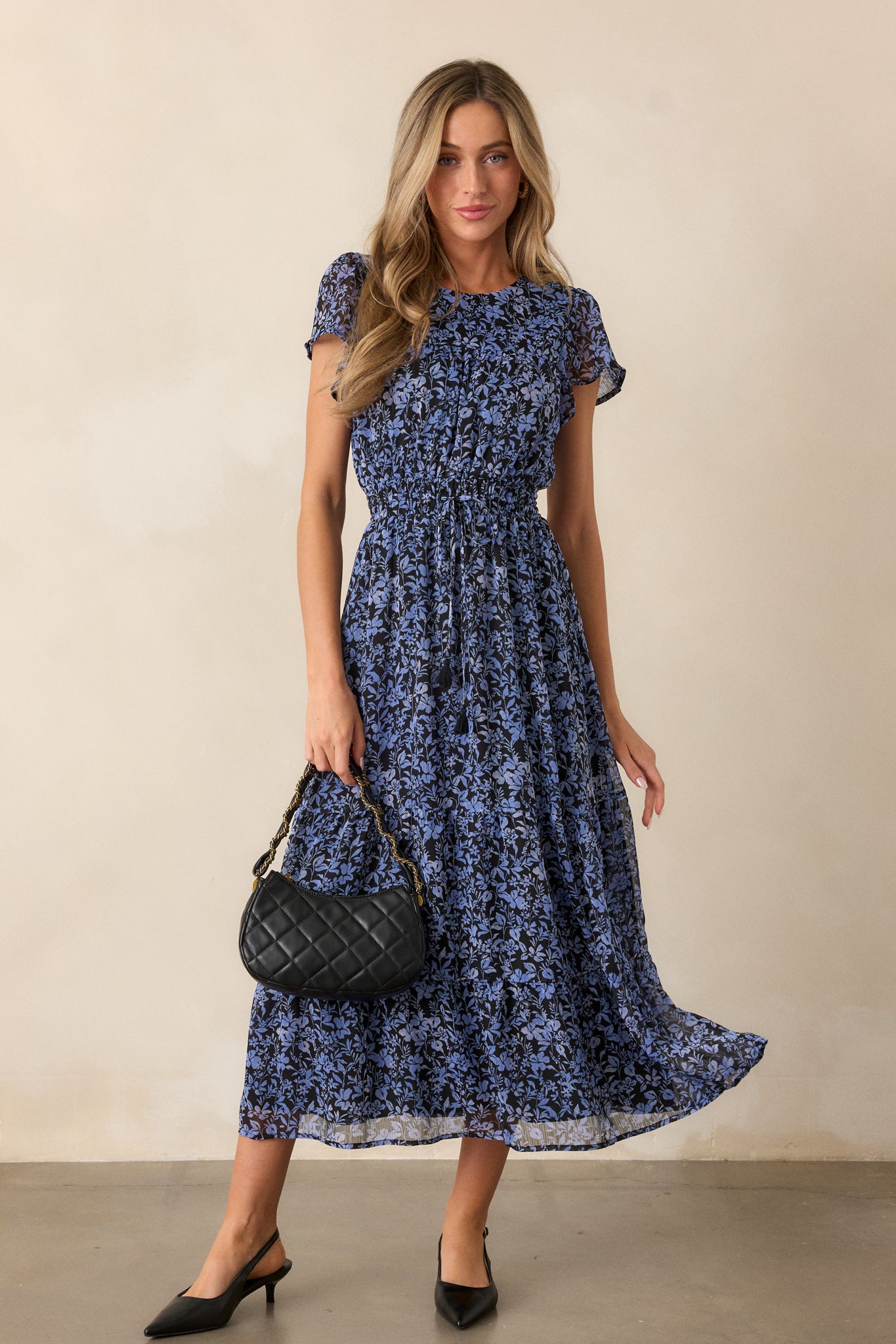 Full front view of the midnight blue dress, showcasing the rounded neckline, self-tie cinched waistband, and flowy skirt with tiered detailing.