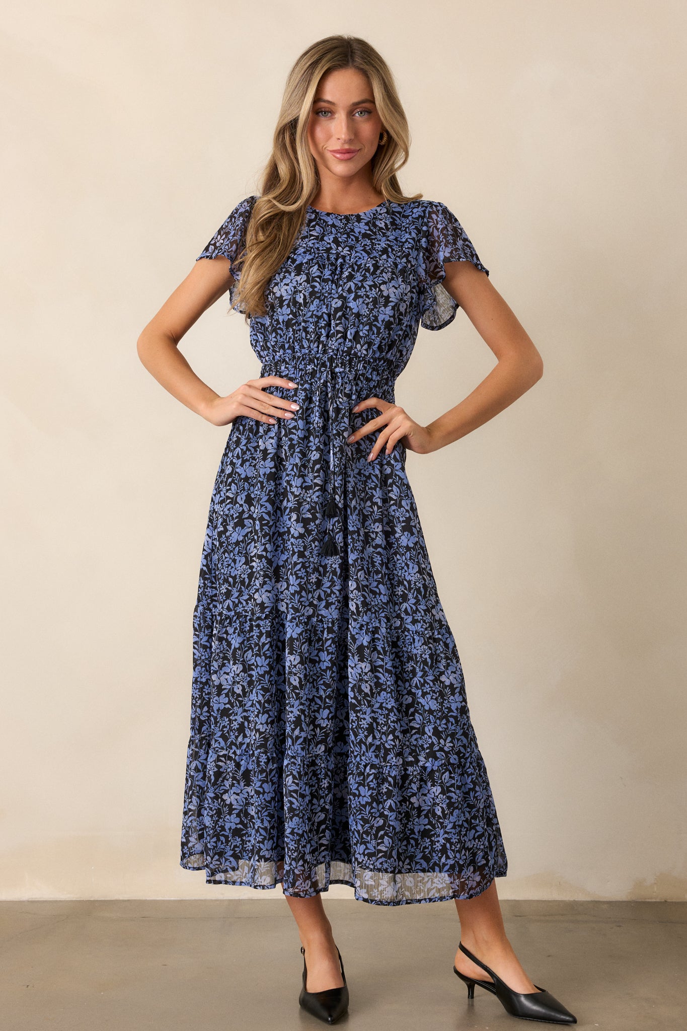 Full length view of the dress highlighting the tiered detailing on the skirt and the soft flow of the fabric from the cinched waist.