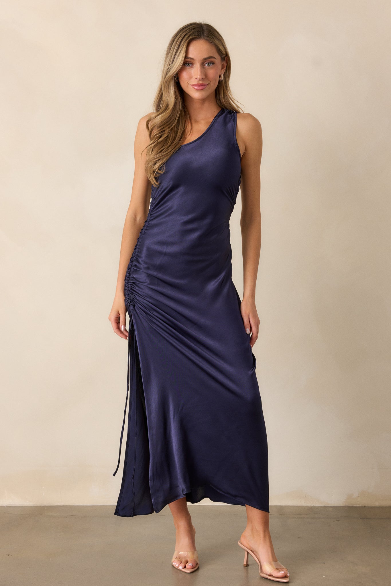 Full body shot view, emphasizing the ruched detailing along the side, the fitted cut, and the side slit, with the sleek design of the dress visible.