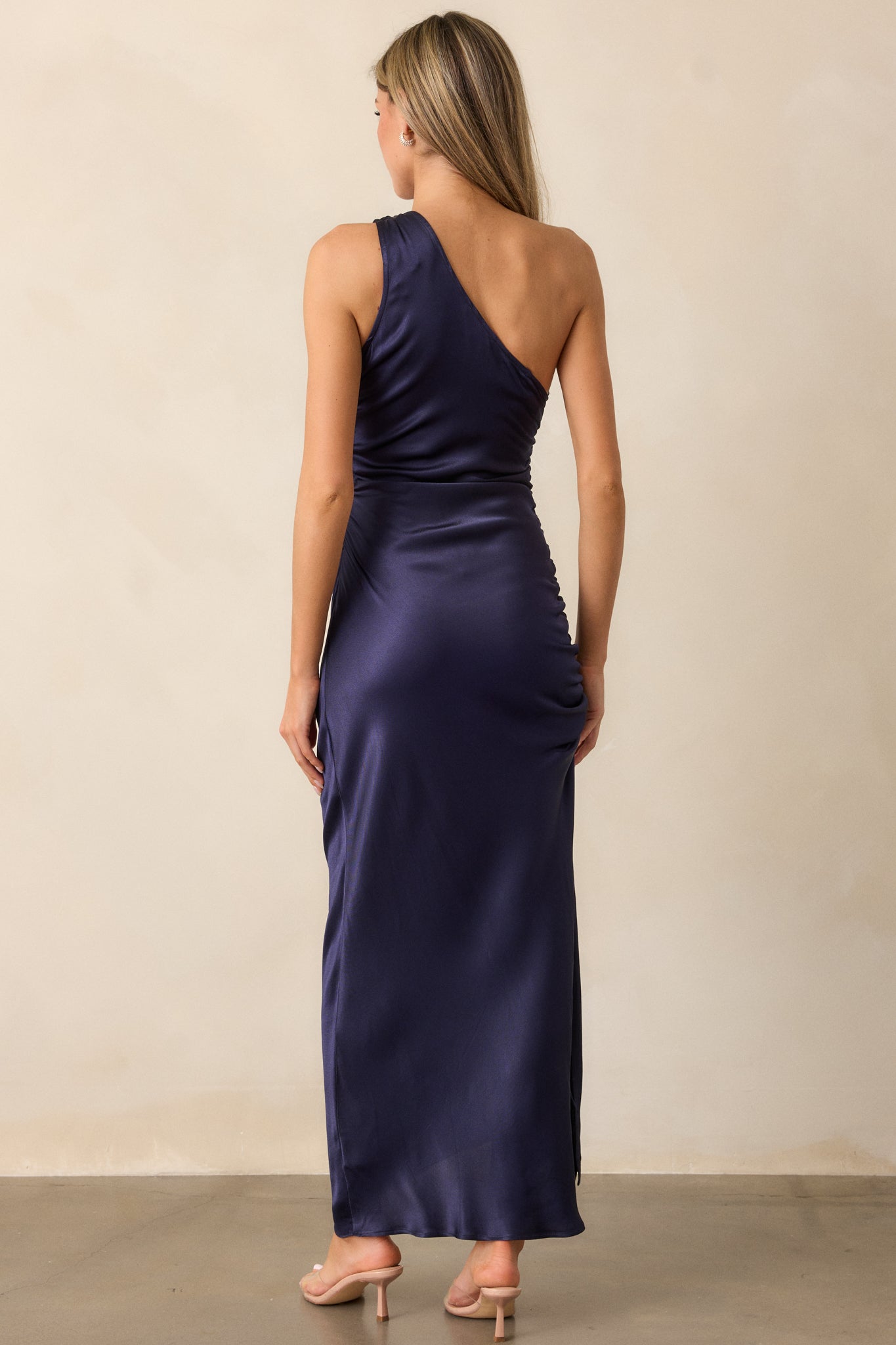 Full back view of the dress, highlighting the smooth fit of the fabric, the discrete side zipper, and the elegant flow of the material along the side.