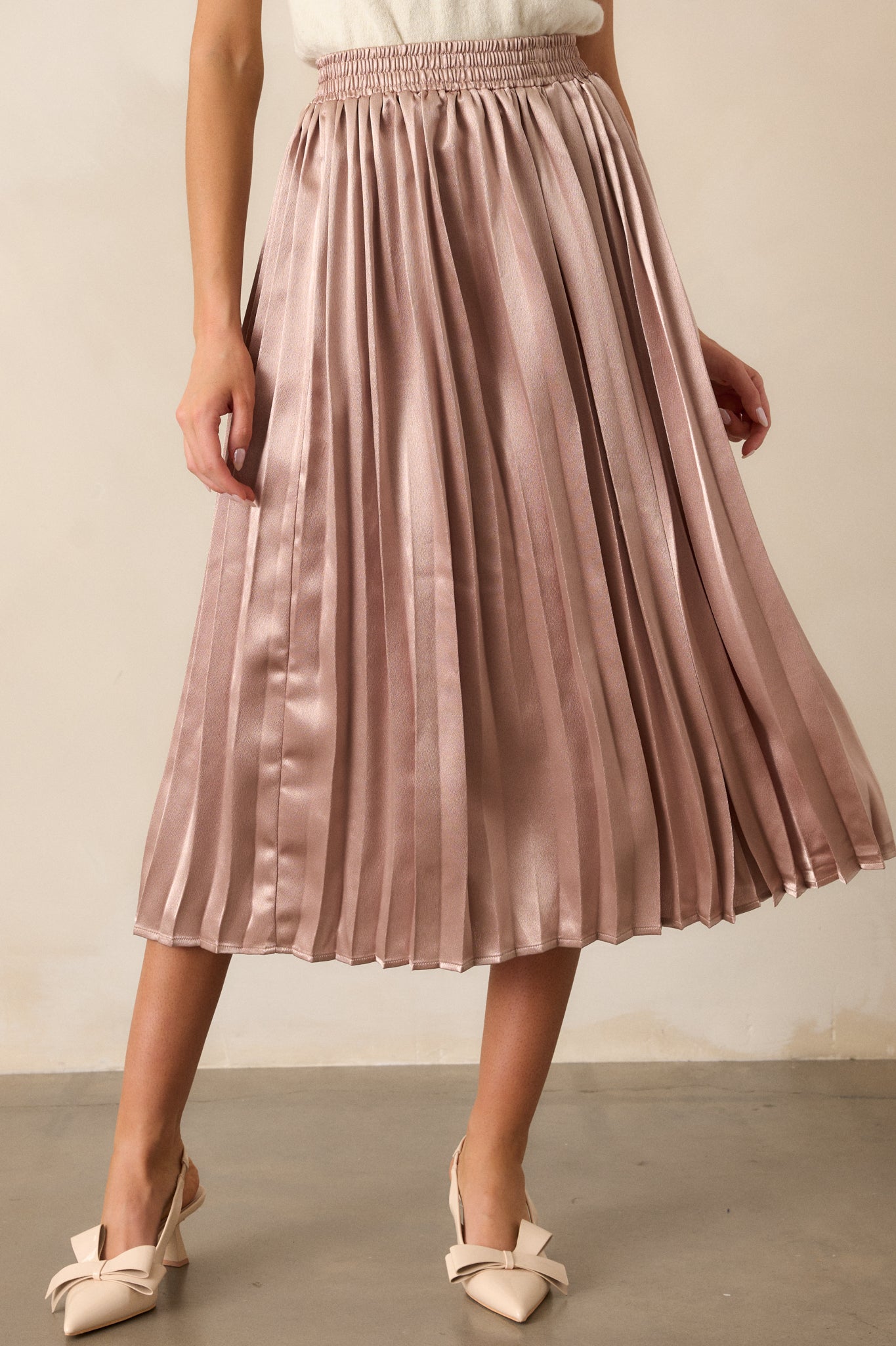 A close-up view of the skirt’s elastic waistband, showing the stretch and comfort, paired with the pleated fabric beneath.