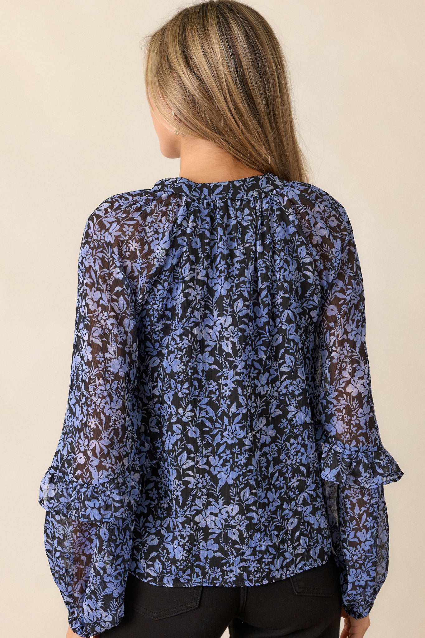 Full back view of the blouse, showcasing the relaxed fit, long sleeves with ruffle cuffs, and the smooth flow of the fabric.