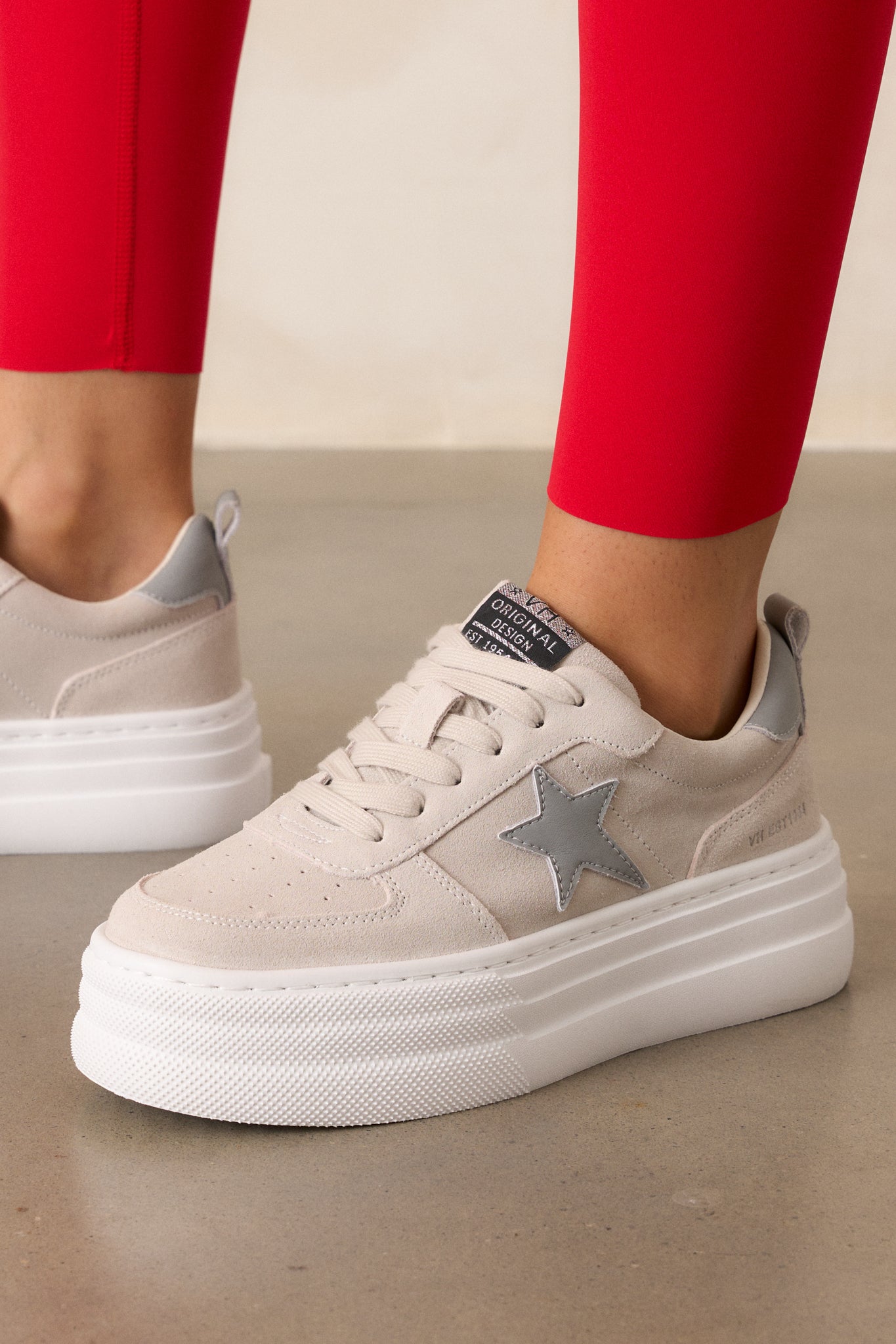 A detailed close-up of the dark grey star on the side of the shoe, with a focus on the texture of the solid grey material. The thick white sole and the dark grey heel tab are also clearly visible, highlighting the shoes' design elements.