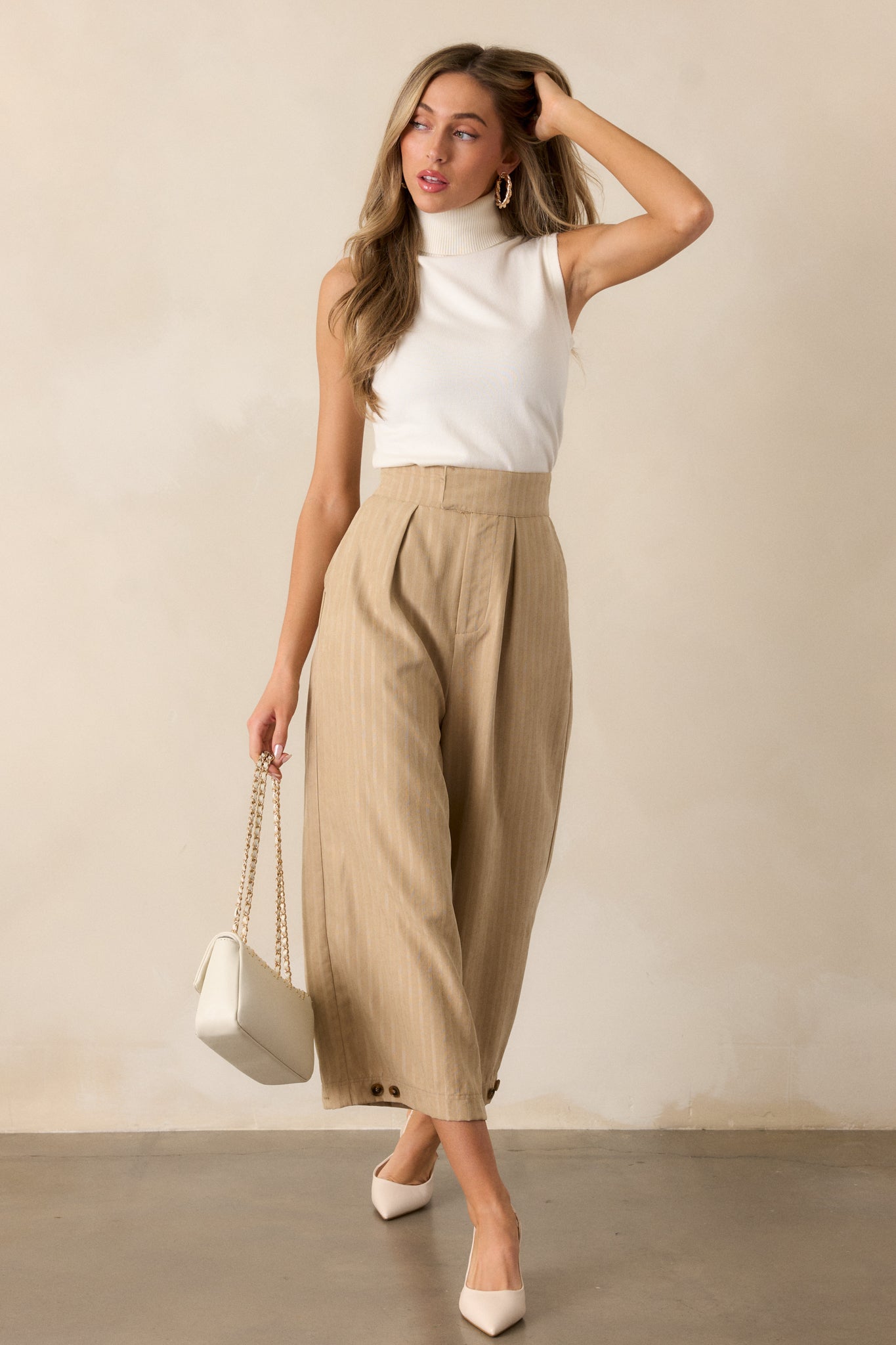 A slightly angled full-body view of the ivory ribbed top, emphasizing its sleeveless design and ribbed texture.