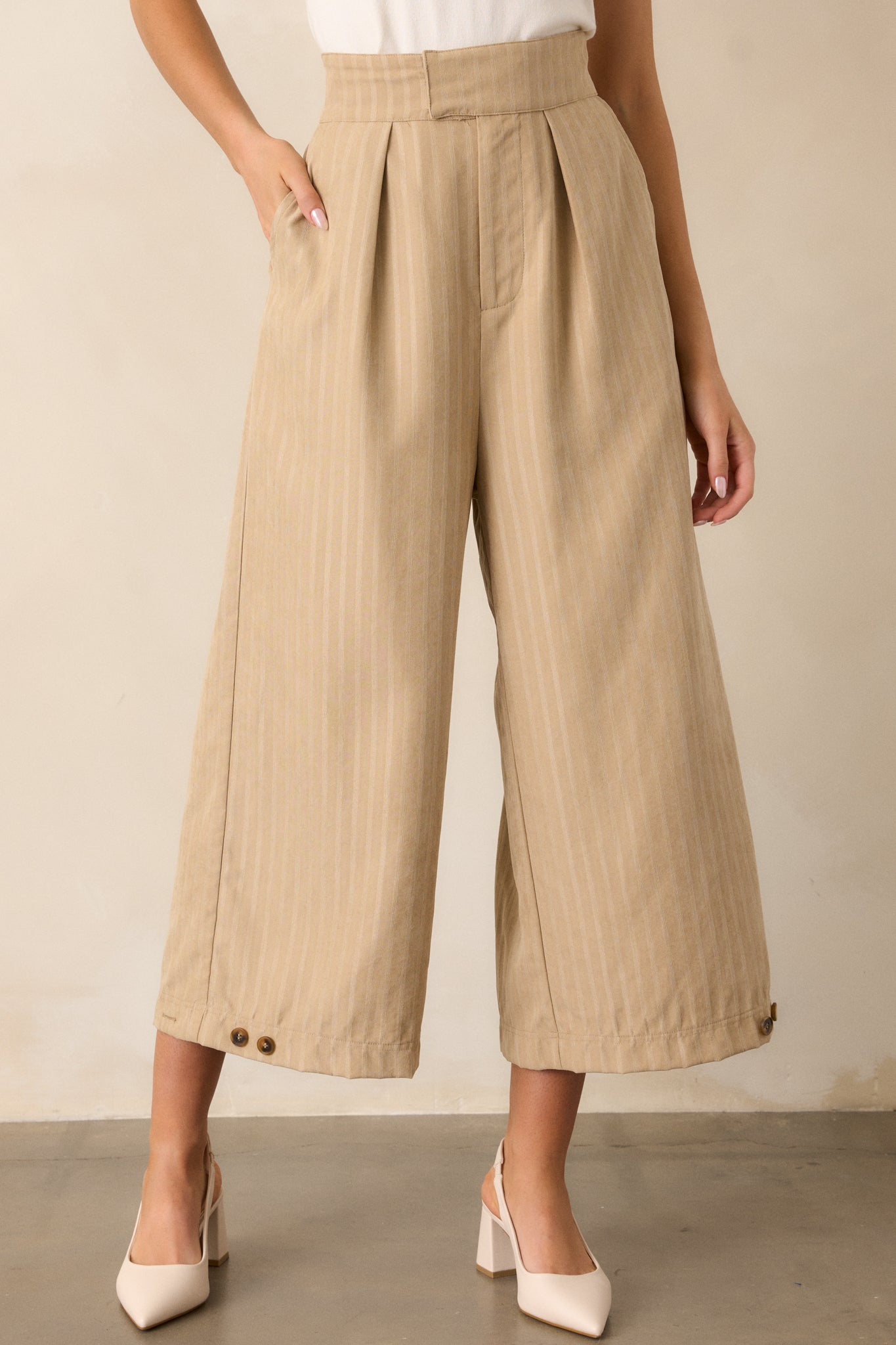 Focus on the lower leg section, emphasizing the cropped length and button cuff detail near the hem.