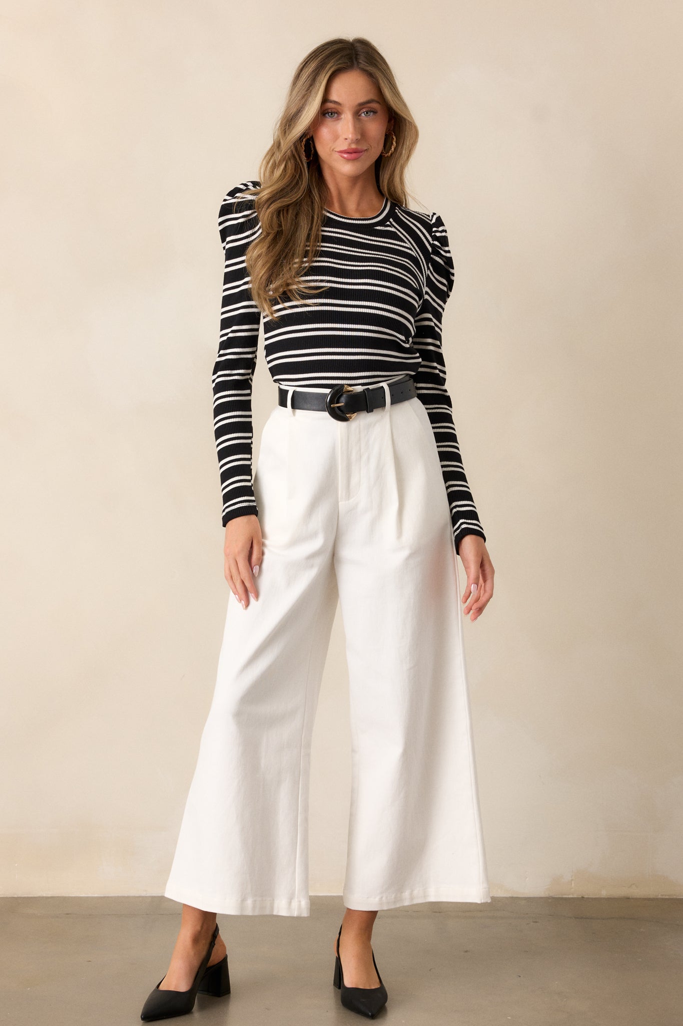 Another full body shot of the black top, showcasing the fitted design, rounded neckline, and white striped pattern across the ribbed knit fabric.