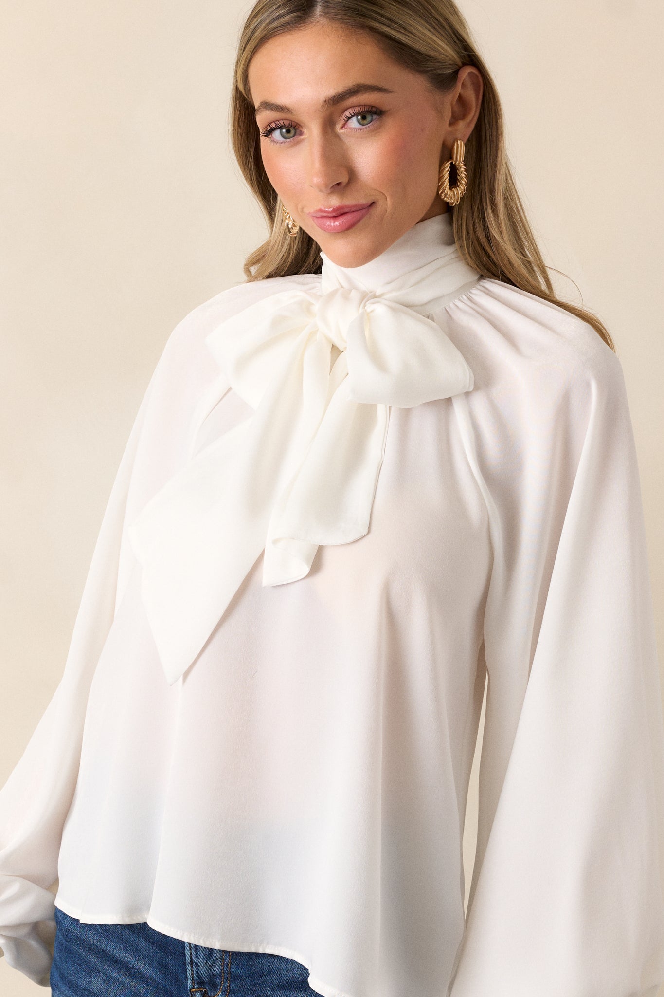 Another cropped shot focusing on the self-tie around the neck, with the balloon sleeves visible. The relaxed, flowy design of the white top gives a laid-back and effortless vibe.