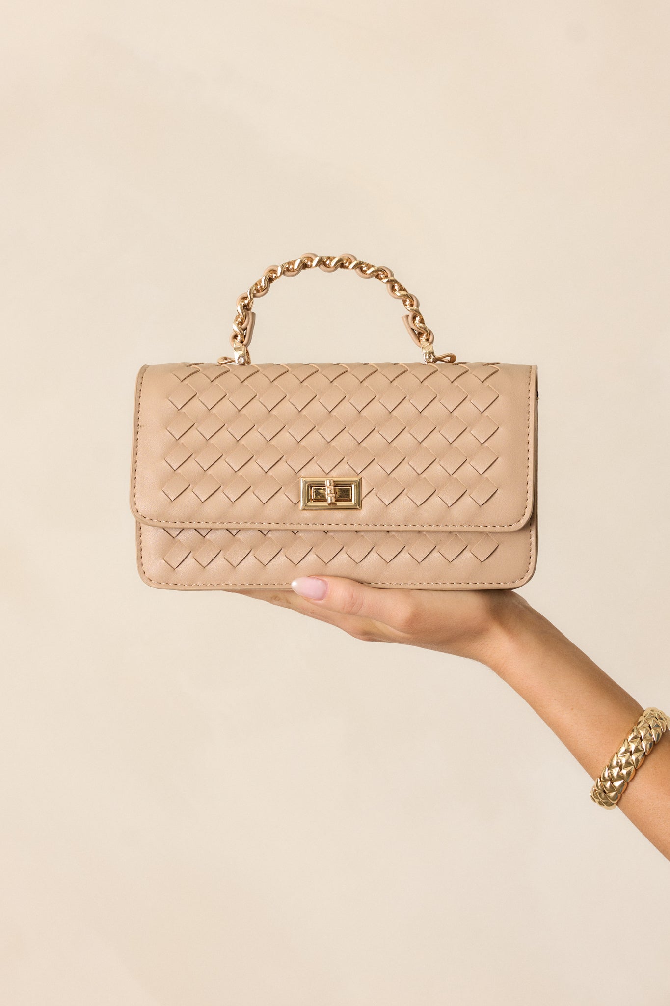 Full view of the rectangular beige handbag with woven faux leather material, showcasing the gold turn lock closure and chain-woven shoulder strap.