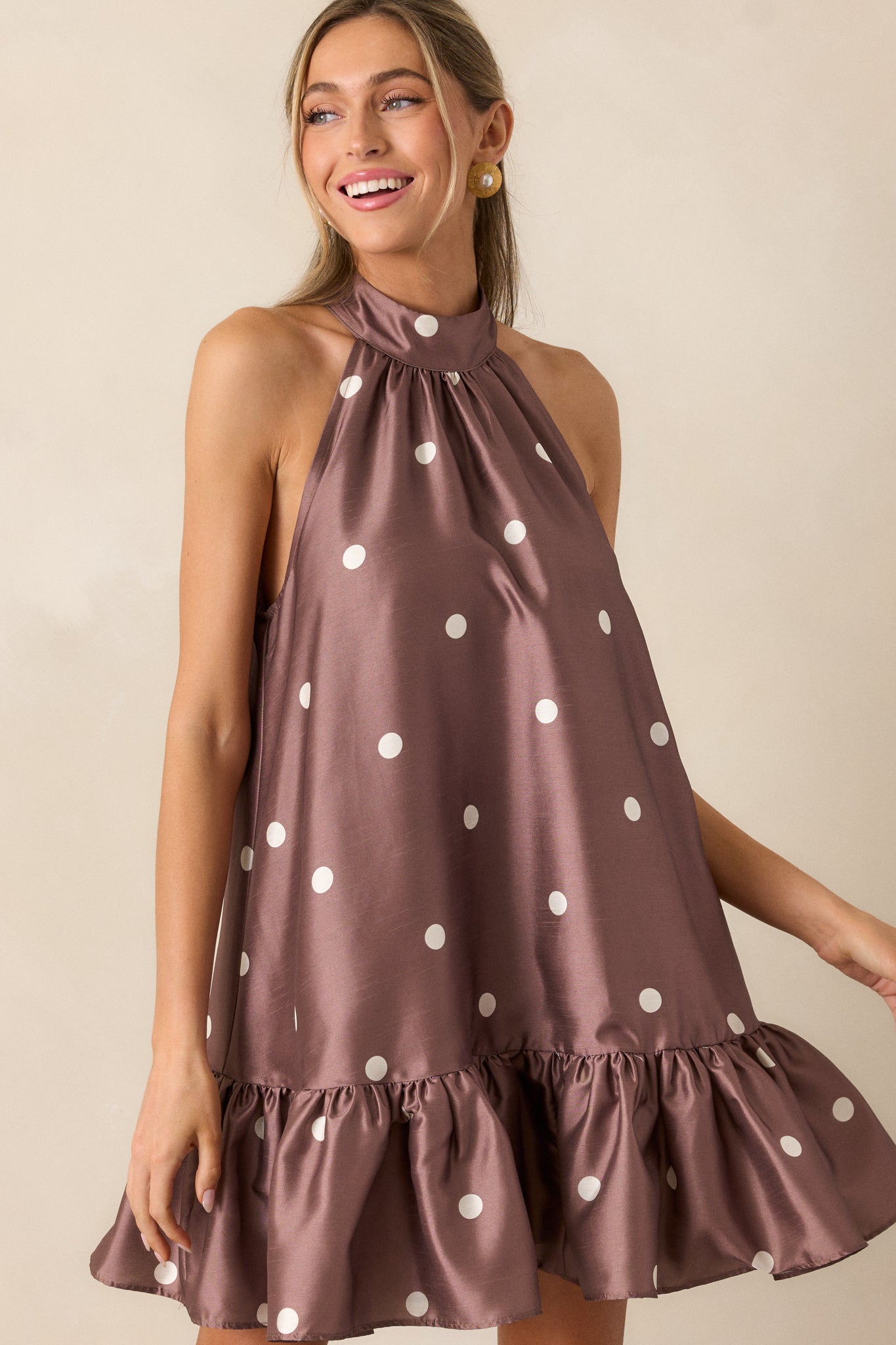 A complete front profile of the dress showing the flow of the babydoll cut and the ruffle bottom hem. The polka dot print adds texture and visual interest to the fabric.