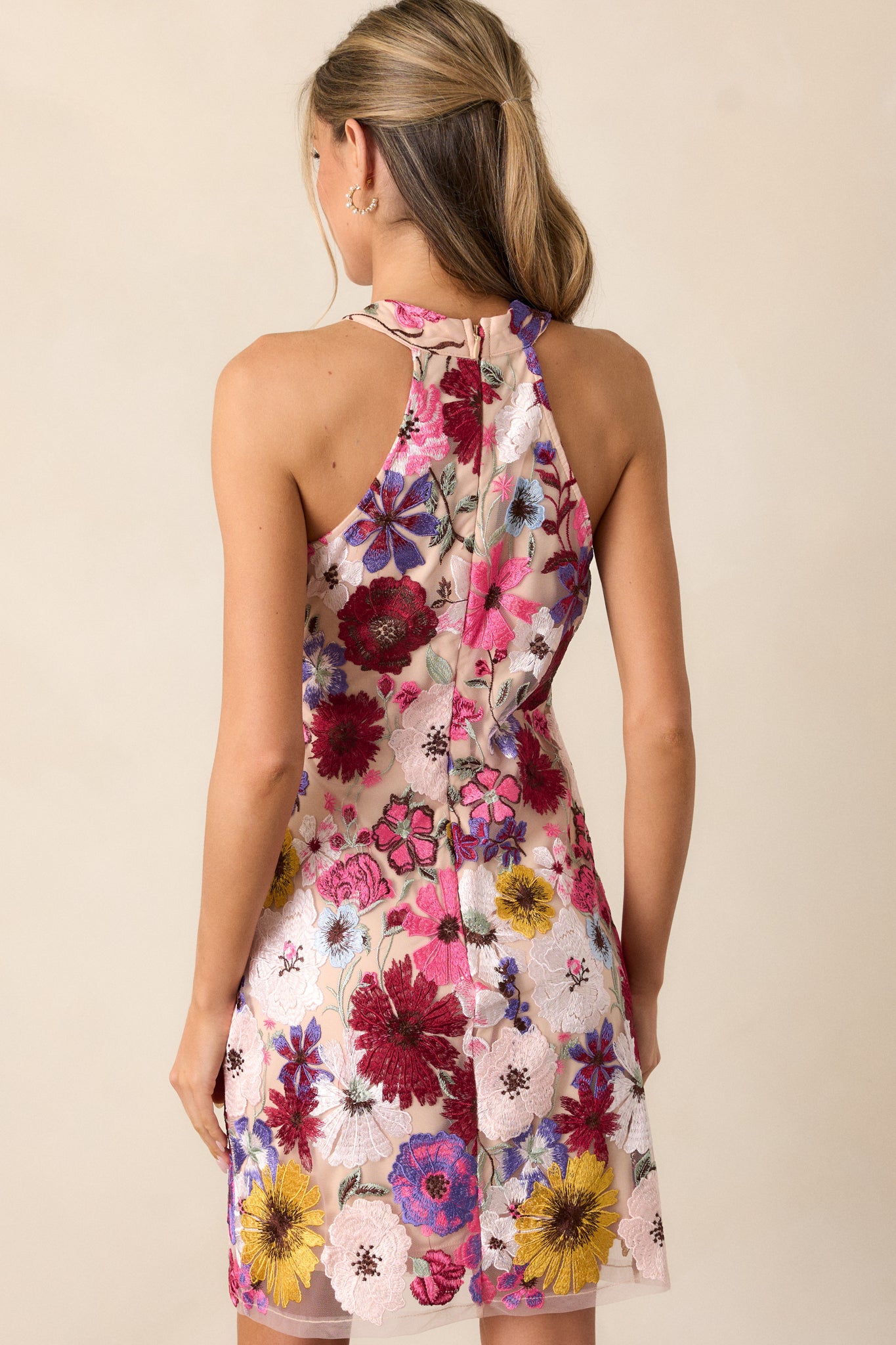 Back view of the dress, displaying the discrete zipper and how the floral embroidery continues throughout the back with a smooth, fitted finish.