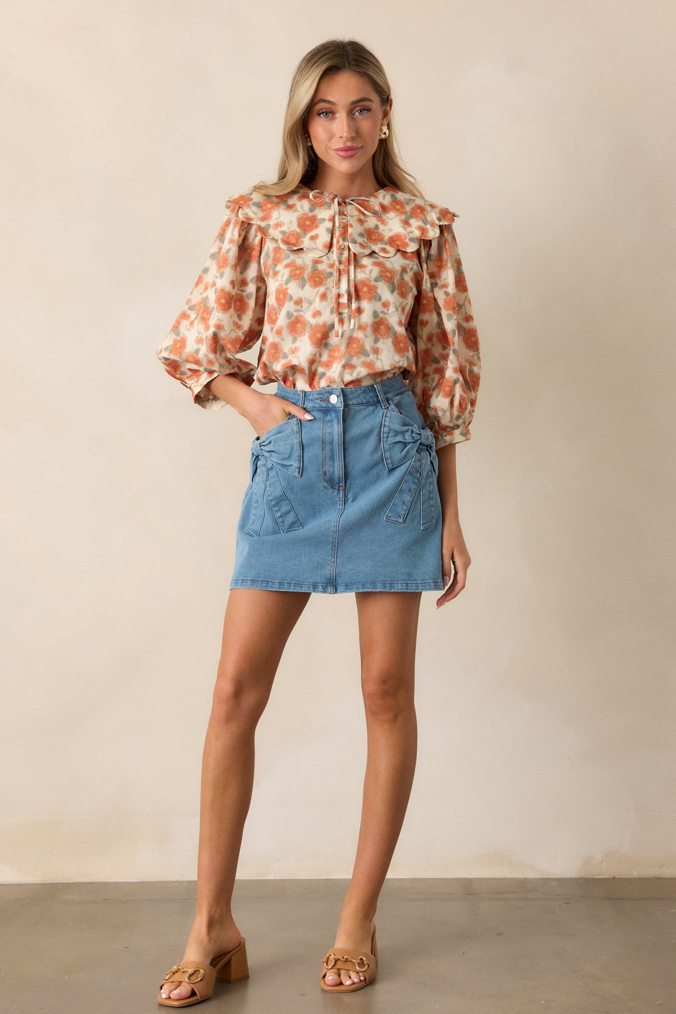 Apricot blouse featuring a delicate floral pattern, 3/4 sleeves, and a peter pan collar with self-tie detail, highlighting the relaxed silhouette.